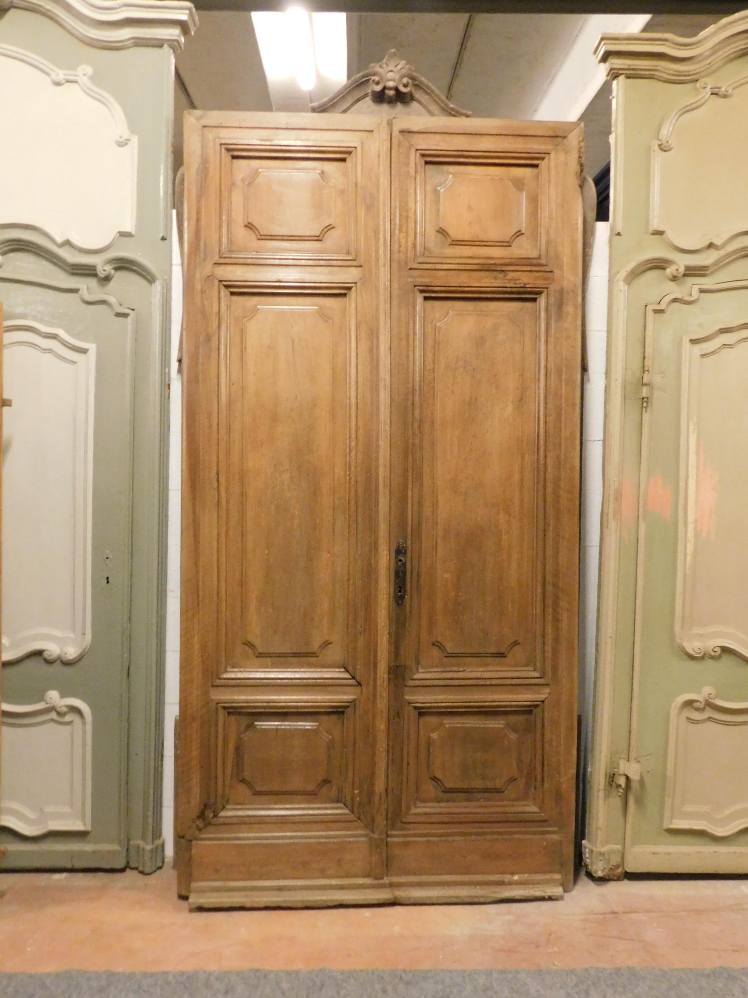 Antique double wing entrance door in honey light brown walnut, hand built in the early 1900s in Italy.
Very elegant and robust structure, in precious walnut, it is sold as it is now, without restoration, but it is in good condition.
It will give a