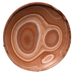 Plato de alabastro con bandas de color naranja y crema del Antiguo Egipto, período predinástico, hacia el 3000 a. C.