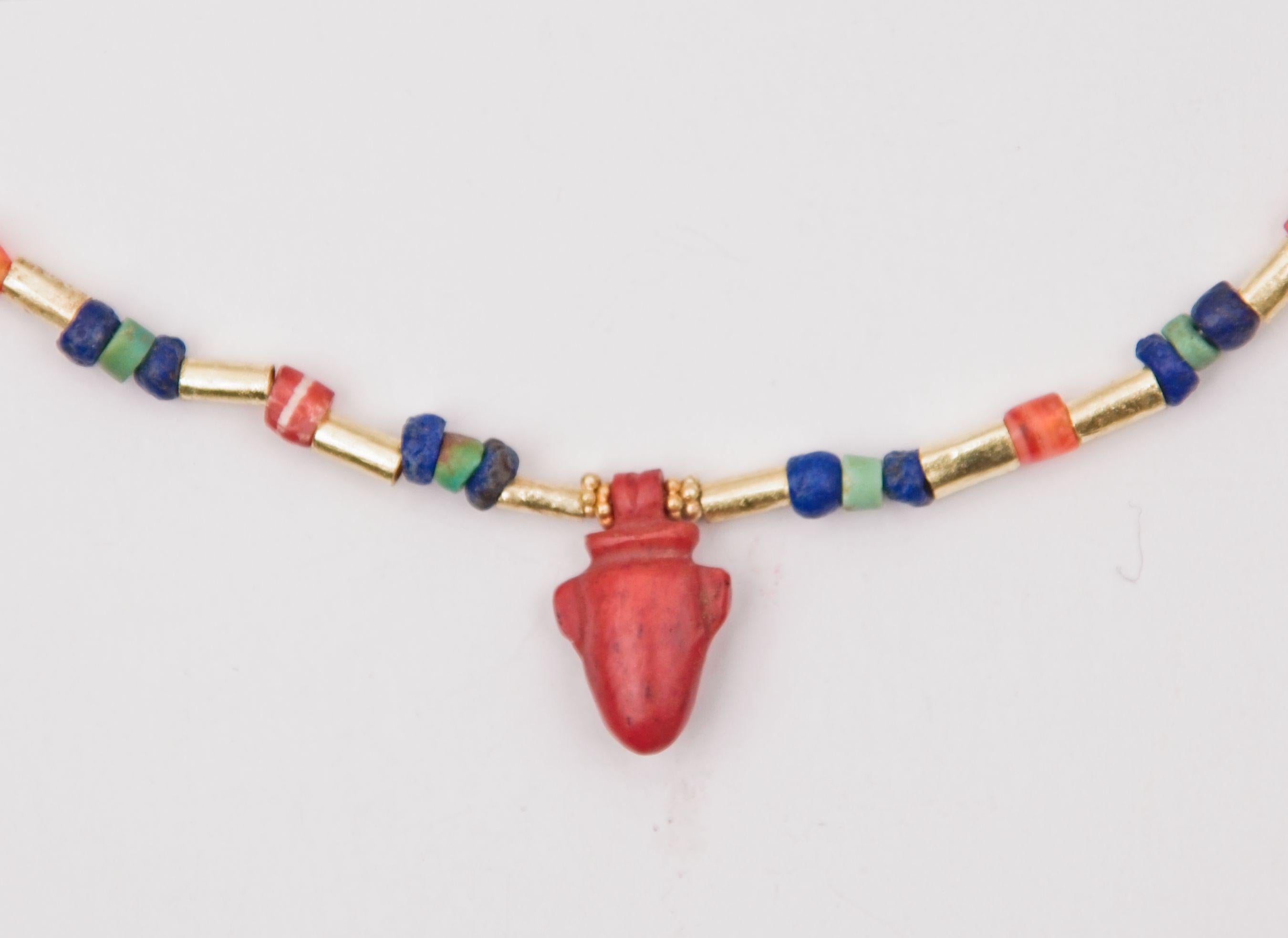 Sixty 22k gold tube beads alternating with thirty groupings of lapis lazuli, turquoise beads, and thirty carnelian barrel-shaped beads. The turquoise and lapis module consists of a small turquoise disc bead faced on either side with a similarly