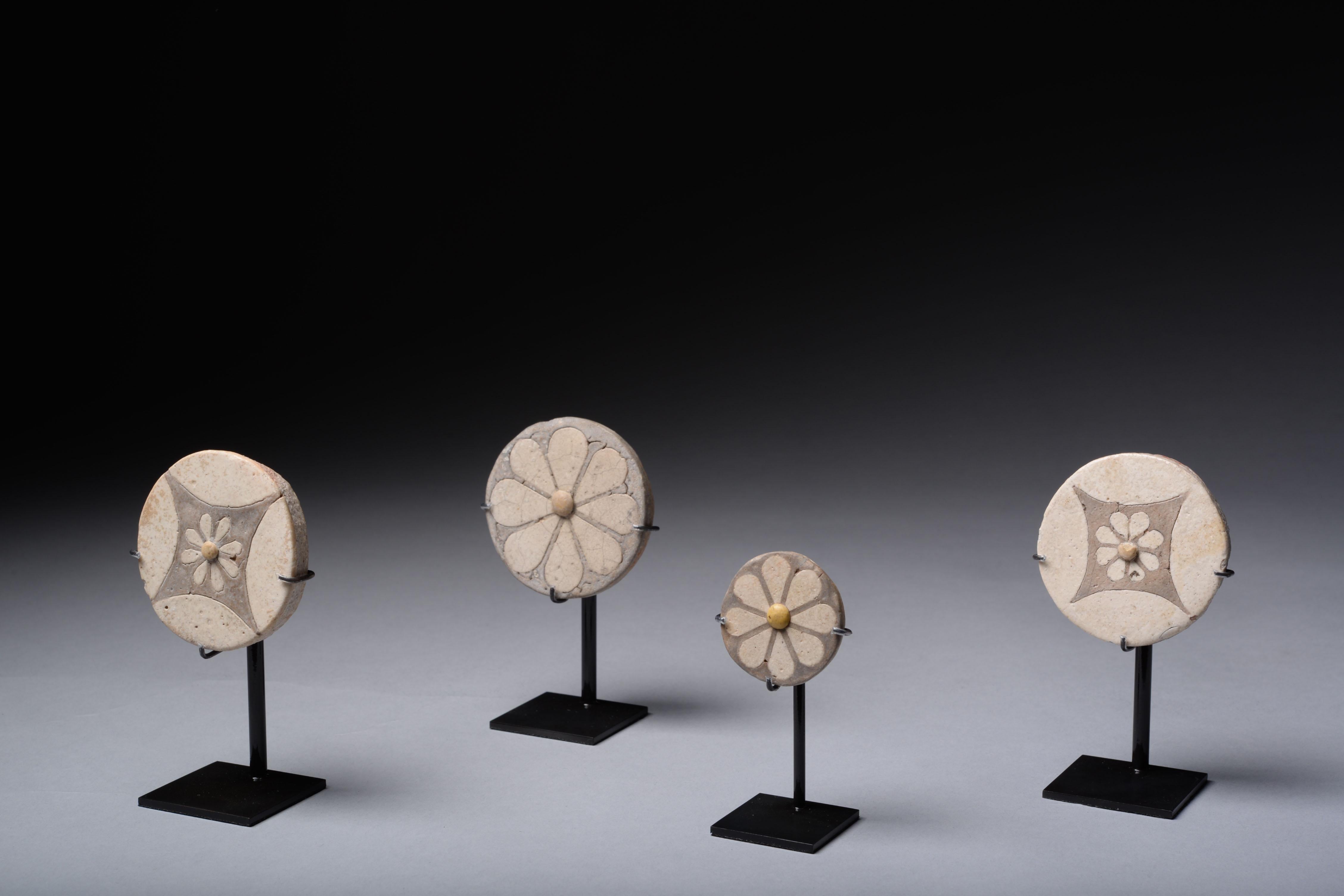 Four Egyptian faience rosettes, dating to the New Kingdom, Reign of Ramesses, 1550-1295 BC.

These remarkable inlays are often called rosettes, though they probably depict daisies or mayflowers. They demonstrate accomplishment in faience artistry,