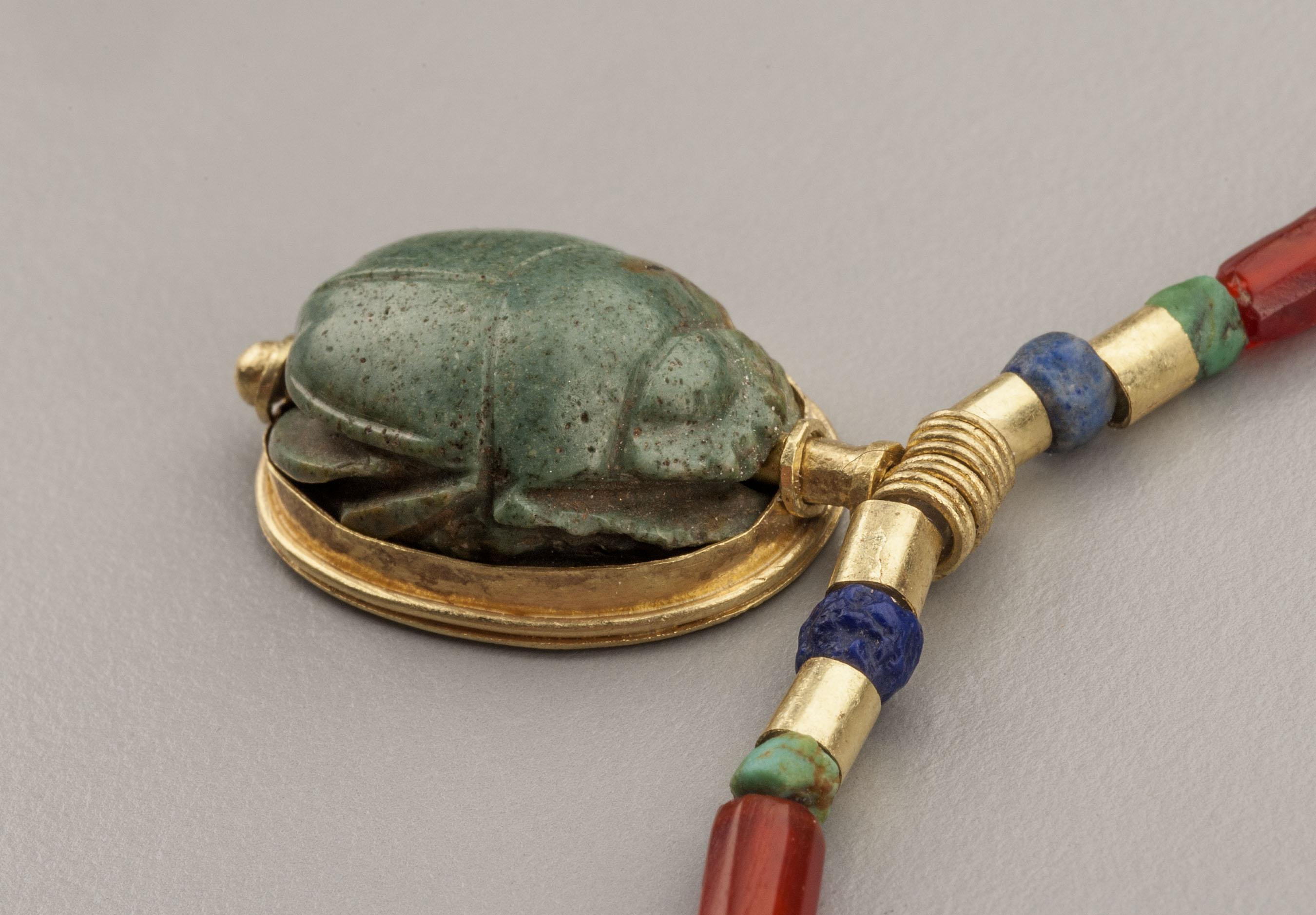 Achtzehn röhrenförmige Perlen aus Karneol, zwanzig Perlen aus Lapislazuli und sechsunddreißig türkisfarbene Scheibenperlen. Jede Lapislazuli-Perle ist mit einem Paar Zylinderperlen aus 20-karätigem Gold versehen, insgesamt vierzig Stück. Jede der