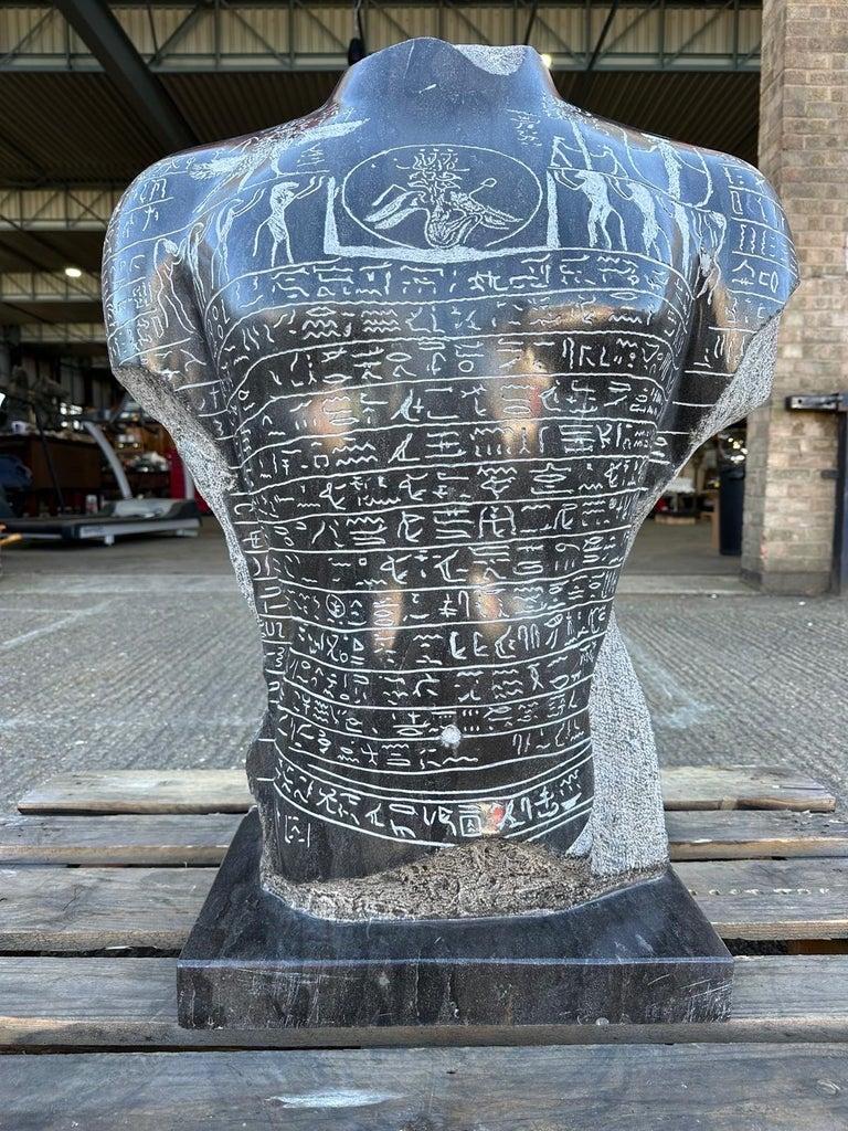La estatua mágica del antiguo Egipto, un busto de granito macizo del siglo XX, presenta intrincados elementos hidrográficos que realzan su significado. En este contexto, la hidrografía se refiere al uso de motivos y símbolos acuáticos, que