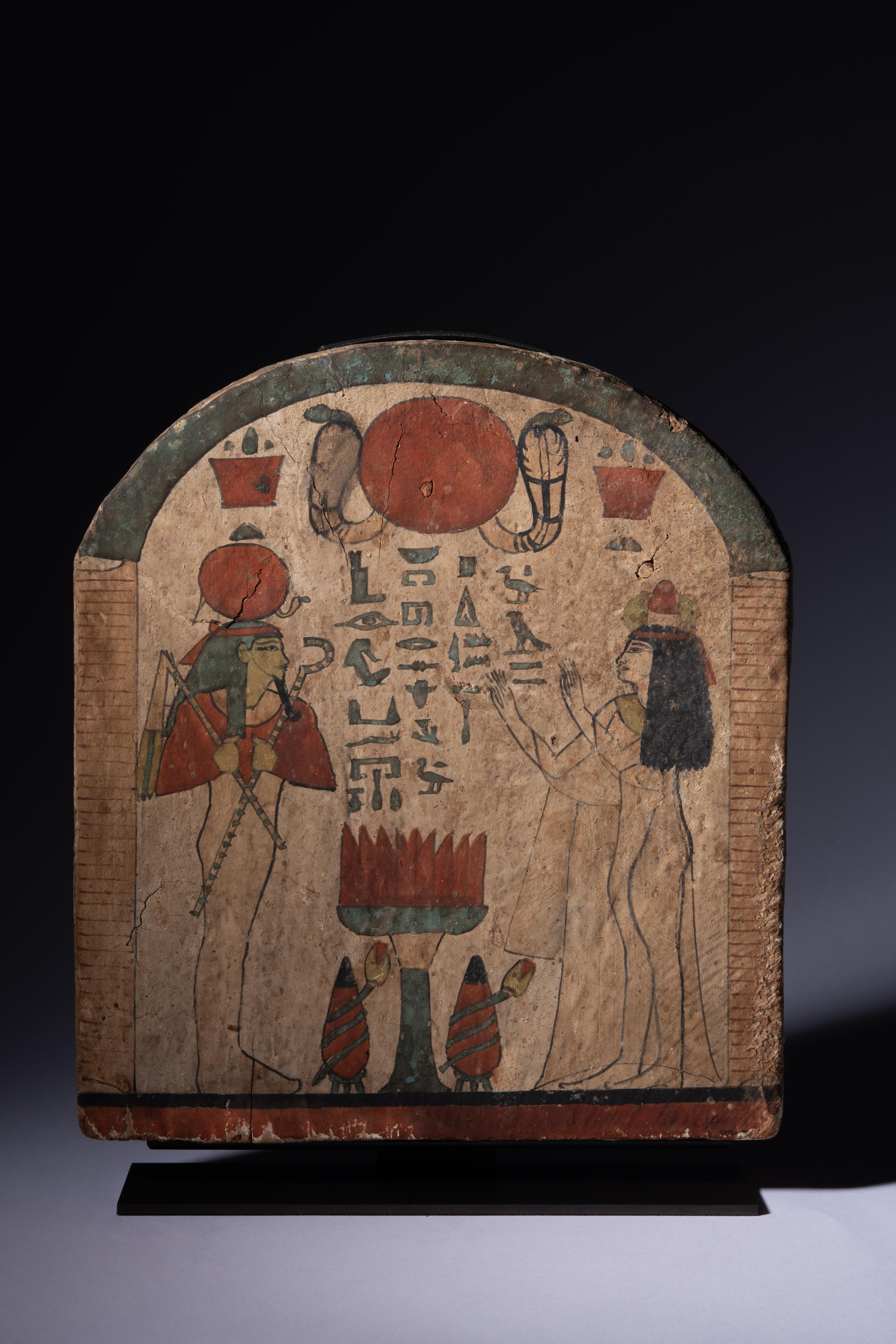Una estela de madera del Tercer Periodo Intermedio, especialmente finamente pintada, que representa a Heres-ib, presentando ofrendas a Osiris. Estela de bulto redondo que representa una escena de ofrenda, enmarcada por hojas de puerta, una bóveda