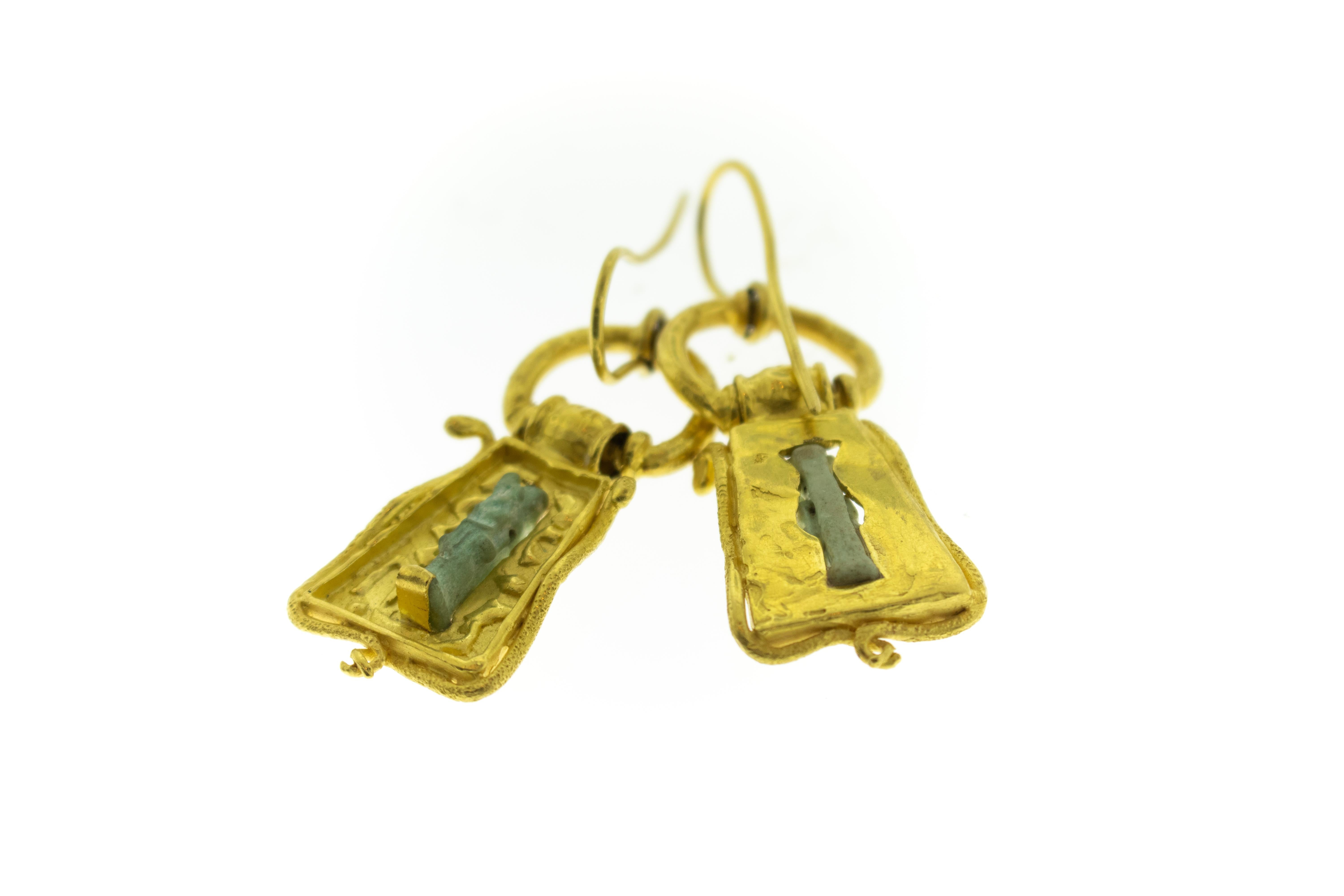 Antike ägyptische Stein Artefakt 22k Gold Ohrringe. Figuren sind eine Farbe wie ein verrostetes Kupfer hellgrün. 22k Gold Gehäuse wurde nicht in der alten Zeit gemacht. Es sind lange Ohrringe mit Haken.  Ohrringe sind 2,25 Zoll lang, 1 Zoll breit