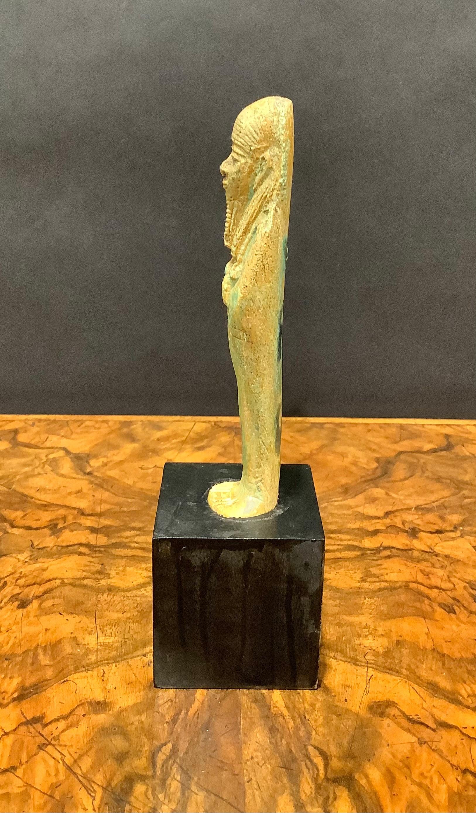 Ancient Egyptian Turquoise Glazed Faience Ushabti of the 26th Dynasty
Good condition, not including the stand.

An Egyptian ushabti, also known as shabti or shawabti, is a small funerary figurine that was commonly placed in tombs and burial sites in