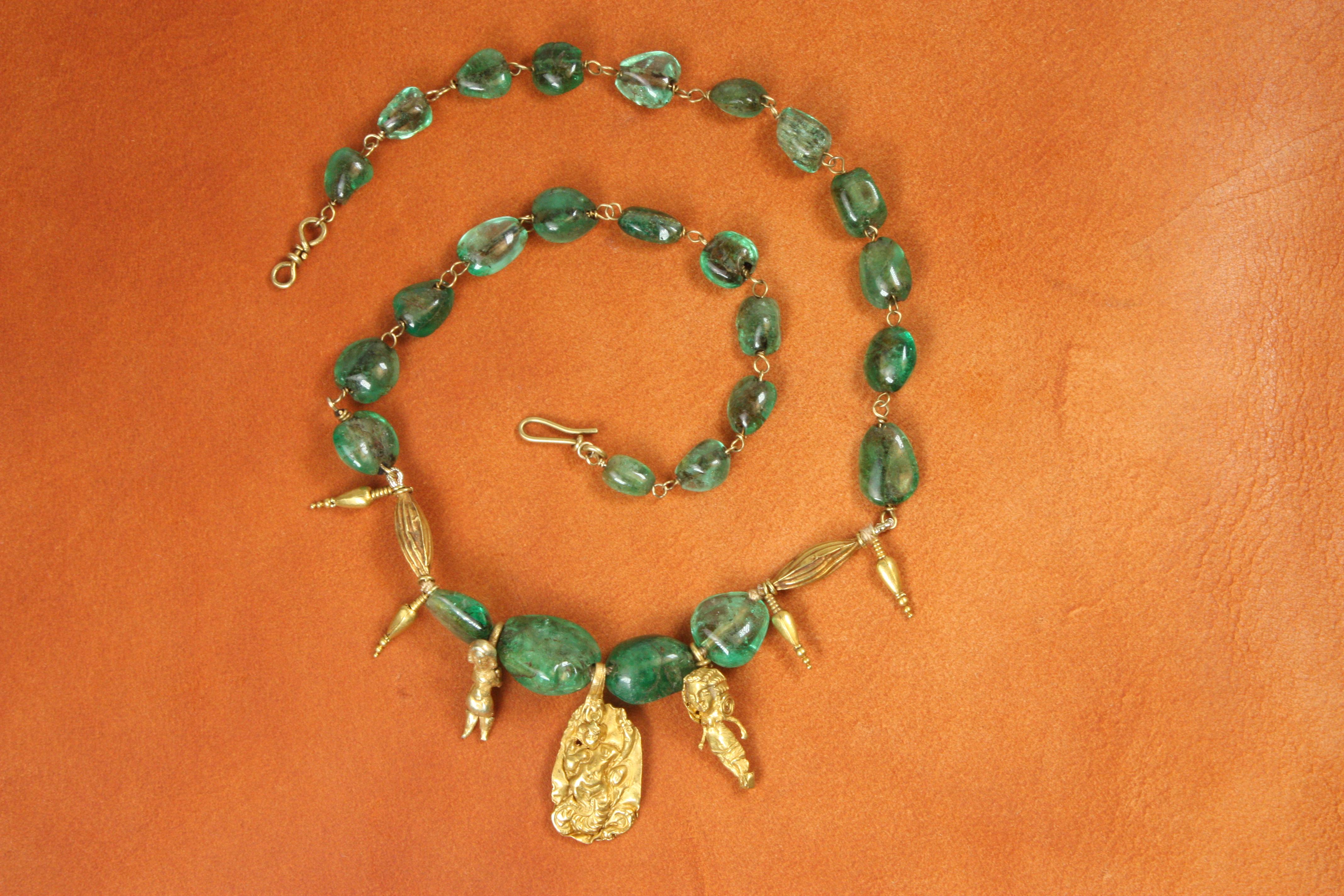 Questa collana di smeraldi antichi è ricca di storia, realizzata con perline e charms greco-romani risalenti a circa 1500 anni fa. Le perle di smeraldo naturale, vibranti e lisce, si aggiungono ai charms in oro giallo: si tratta di manufatti