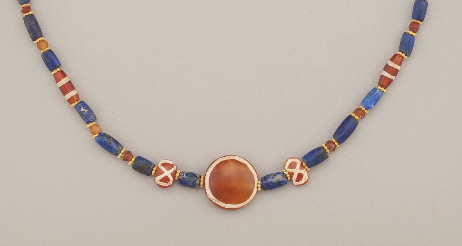 Twenty-seven carnelian beads, nine of which are patterned (commonly called “etched” carnelians), alternating with twenty-eight lapis lazuli beads. Each ancient stone bead is separated by a granulated 22k gold ring bead, fifty-four in all. The