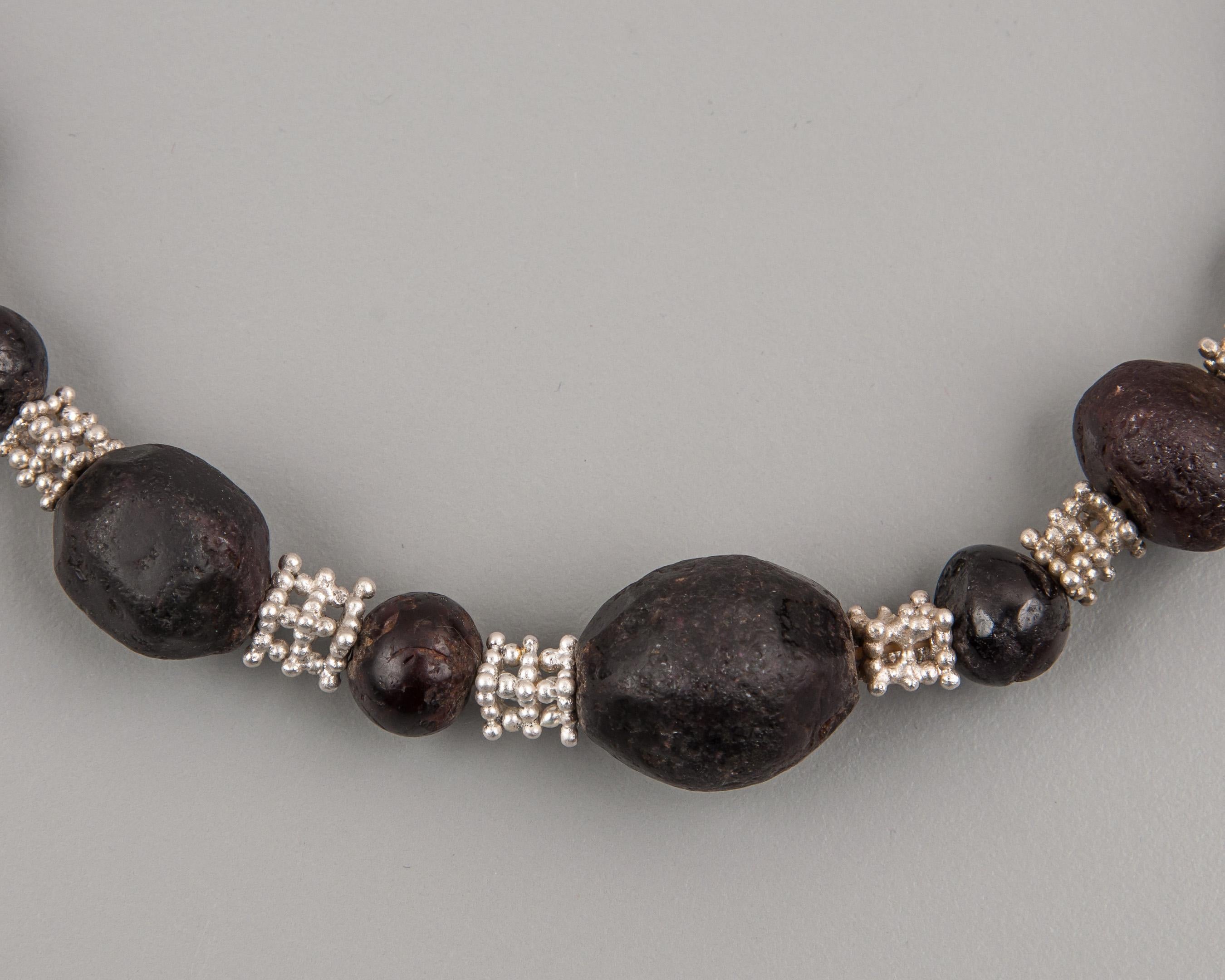 Twenty-three ancient garnet beads alternating with granulated silver beads composed of forty-four silver granules fused together in five layers to form a rectangular solid with two openings in each face. The garnet beads are large and show much