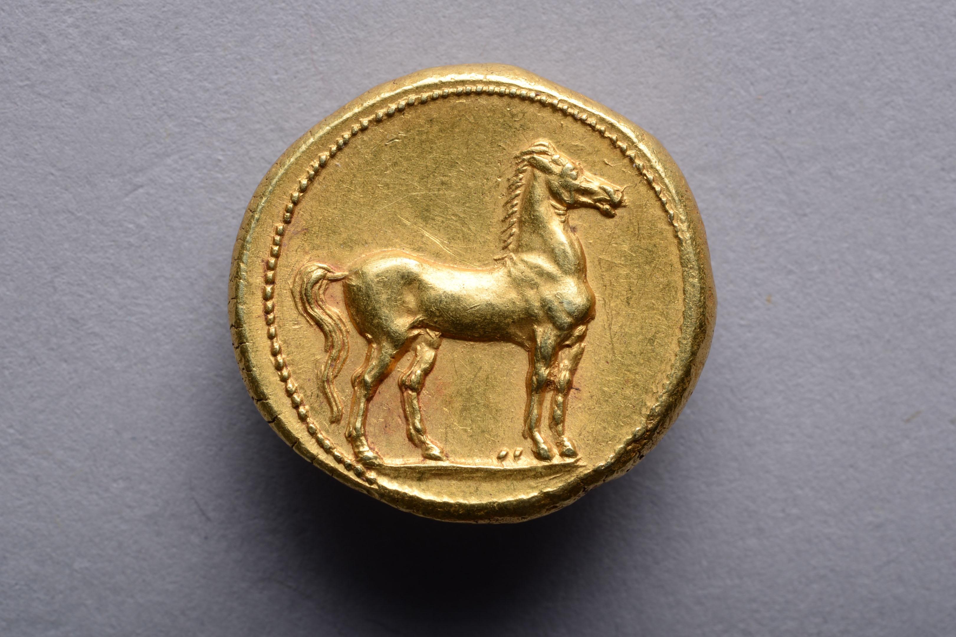 A Punic gold stater minted in Carthage, circa 310 - 270 BC.

The obverse with the portrait of Tanit, chief goddess of Carthage, wearing triple drop earring and a necklace made of wheat ears, her hair bound with a wreath of grain.

The reverse