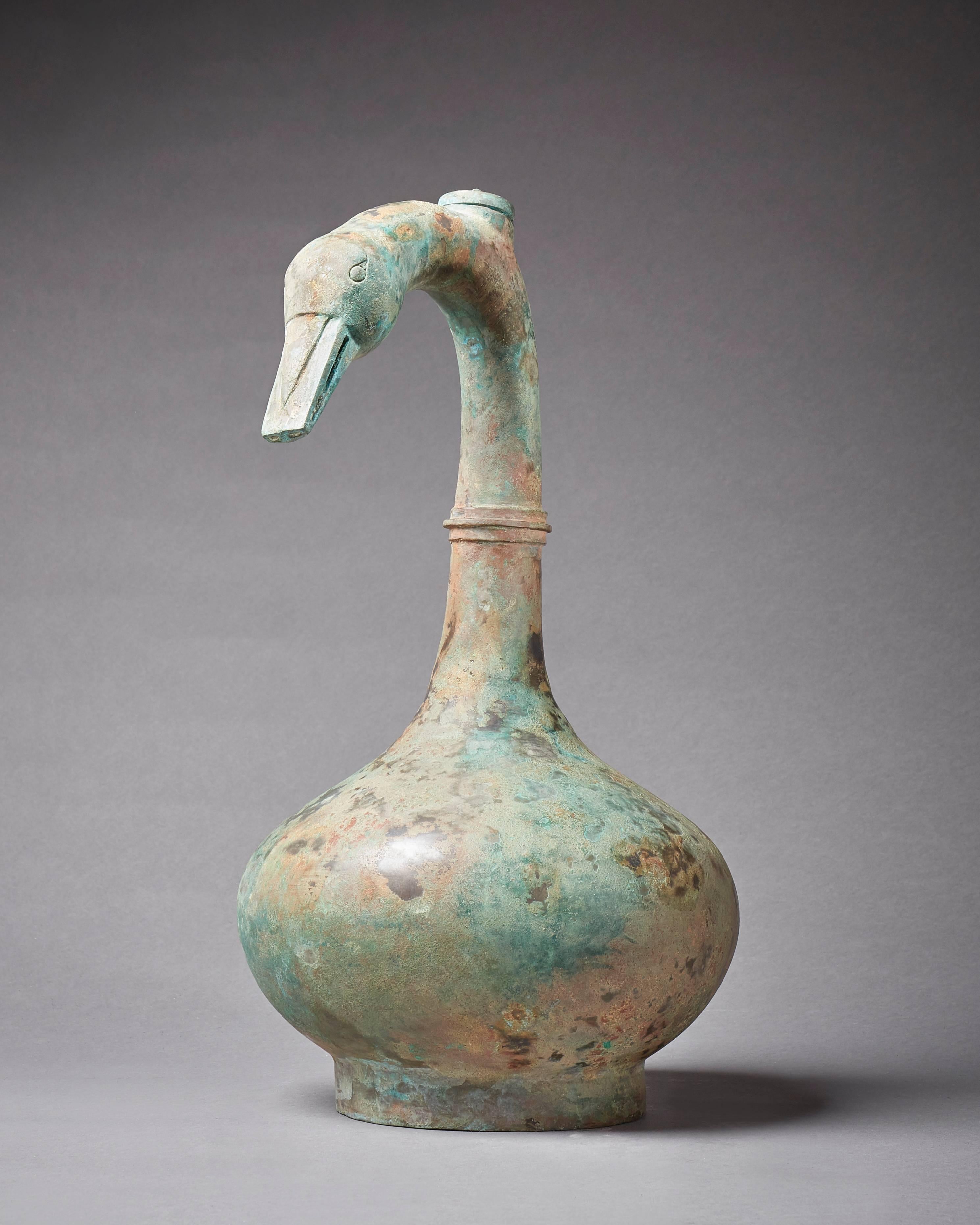An ancient goose-neck vessel
The bulbous body raised on a circular foot, a rounded collar dividing the curved neck, a circular upright mouth rim at the crest and a simplified goose head at the tip
China
Han dynasty (206 B.C. - A.D.