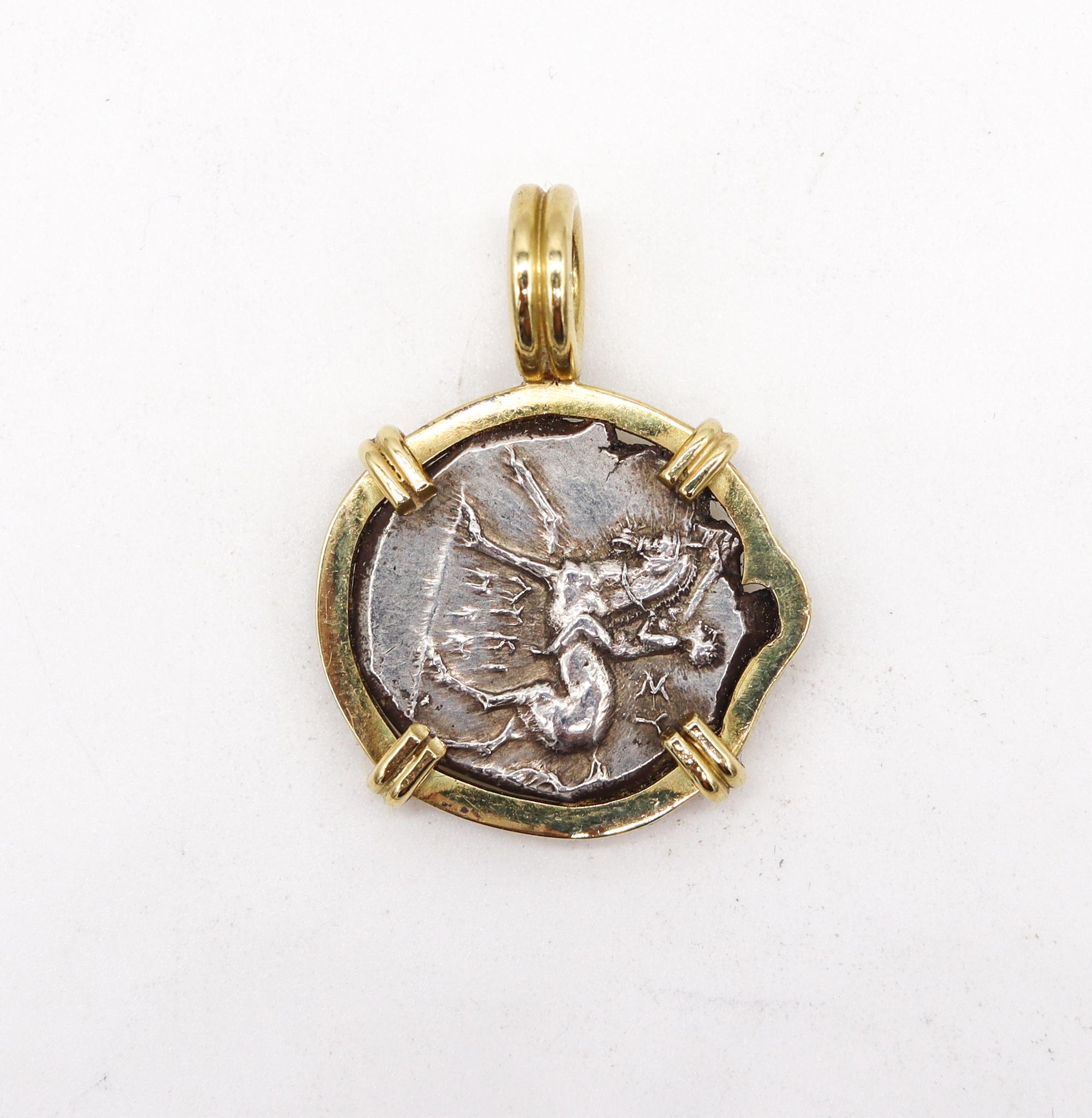 Riding boy in a dolphin framed coin pendant.

An ancient silver coin of one Nomos or Stater struck between 272 - 240 BC in the Greek portuary city of Tarentum, located in Calabria in the very southern Italy.

This coin is carefully mounted in a