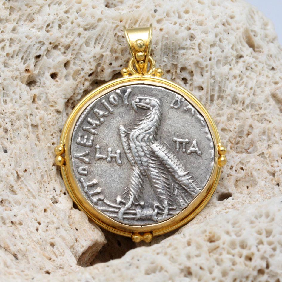 An authentic, Ancient Greek silver tetradrachm from the later Ptolemaic Dynasty in Egypt is set in this ancient-inspired handmade 18K setting with round wire and double 