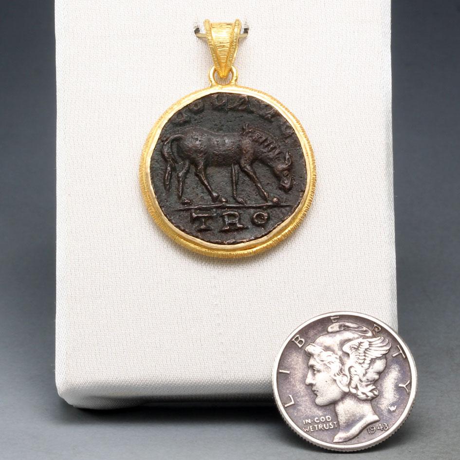 A large, highly detailed, authentic bronze coin from Alexander Troas (in what is now western Turkey) depicts a horse grazing on one side and the goddess Tyche on the other. The horse was a symbol of power and strength in the ancient world. It was