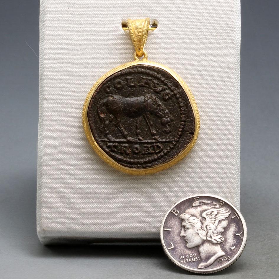 A large, highly detailed, authentic bronze coin from Alexander Troas (in what is now western Turkey) depicts a horse grazing on one side and the goddess Tyche on the other. The horse was a symbol of power and strength in the ancient world. It was