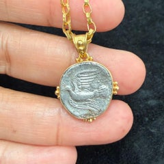 Ciondolo in oro 18 carati con colomba, ispirato a un'antica moneta greca in argento del IV secolo a.C.