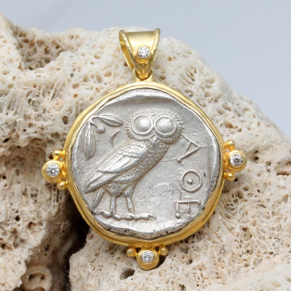 An iconic ancient Greek Athenian owl coin from 475-425 BC is held in a handmade 18K gold bezel surrounded by a 