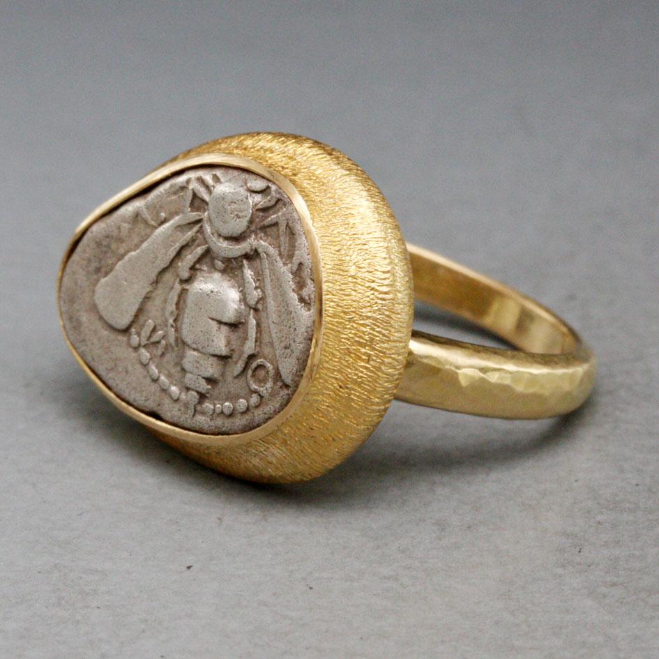 An authentic ancient early Greek silver drachm coin from Ephesus 500- 420 BC, with the beautiful depiction of a bee, is held in a simple wide line textured bezel and hammered matte-finish shank in this ancient-inspired Steven Battelle designed ring.