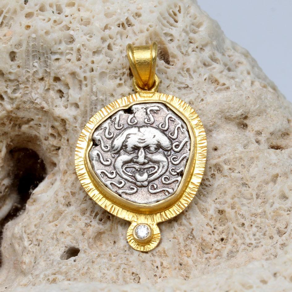 The powerful image of the facing head of a Gorgon, a mythical creature with serpents for hair is the centerpiece of this 18K gold pendant designed by Steven Battelle.  In ancient Greece, the Gorgon, particularly Medusa, was a fearsome beast whose