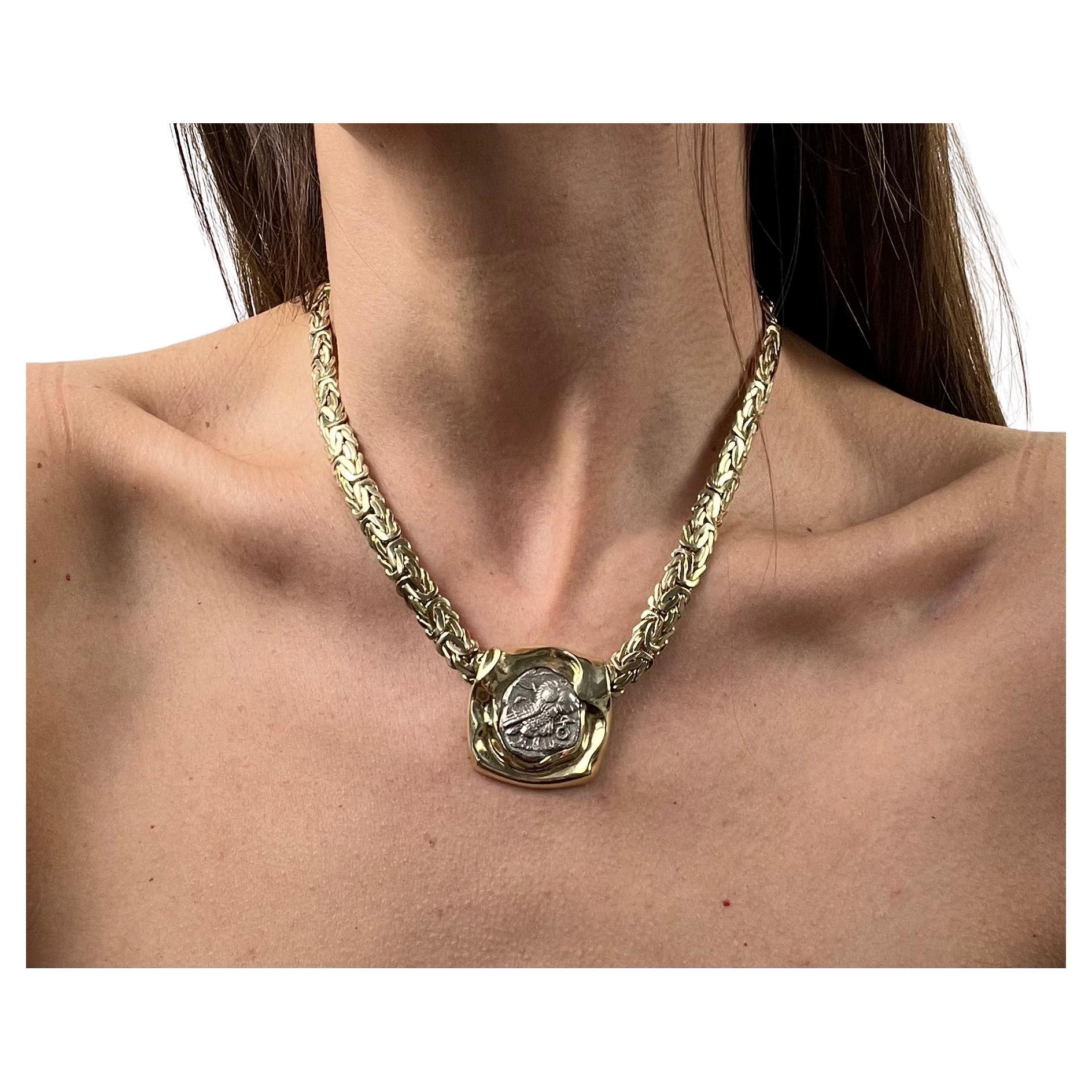 One 14 karat yellow gold Byzantine chain necklace set with one Ancient Greek Athena and the Owl Silver Tetradrachm circa 450 BC coin pendant. The necklace measures 16.5 inches long and is complete with a lobster claw clasp.  The necklace weighs 70.3