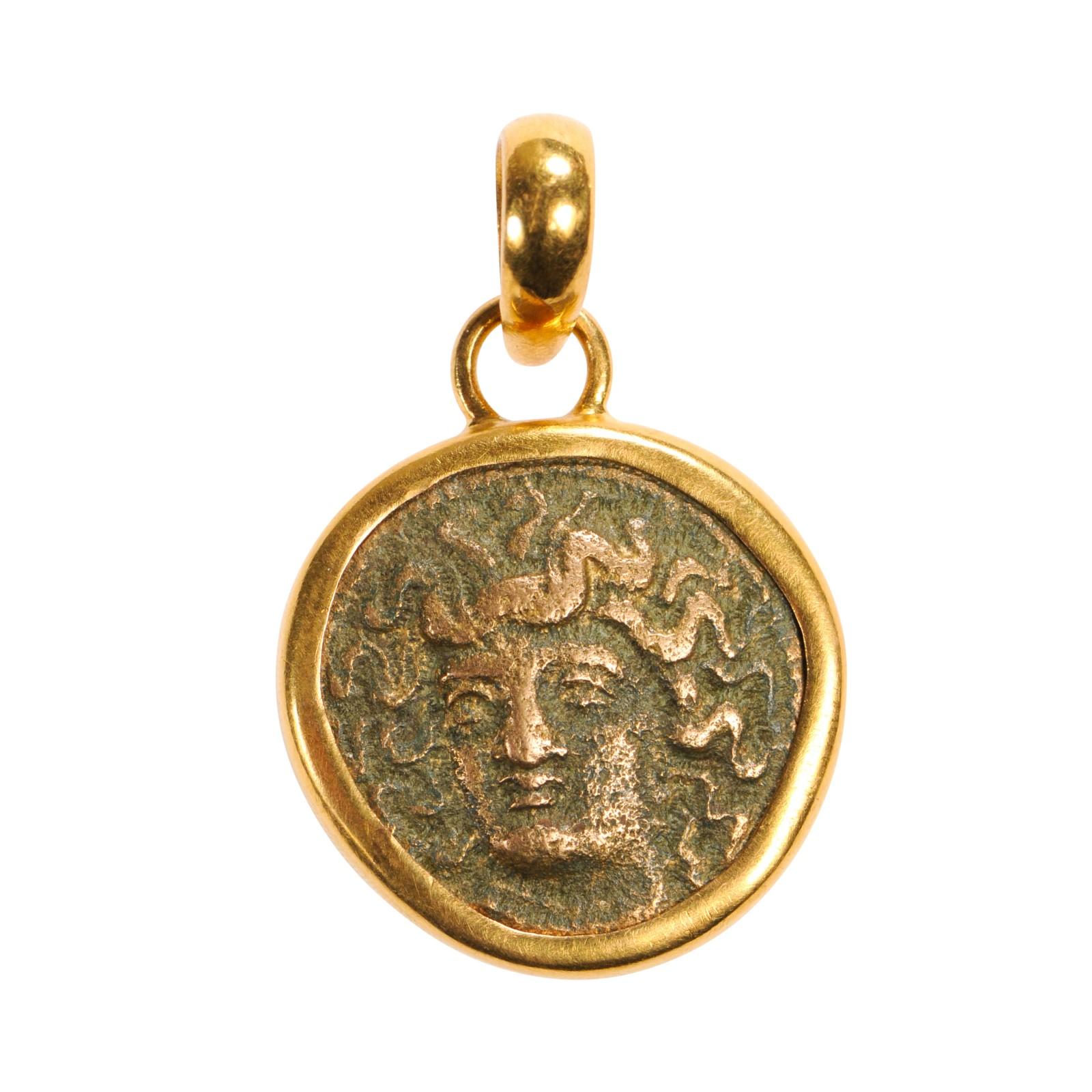 An Authentic Greek bronze Tetrachalkon coin (circa 400-344 BC). This ancient Greek coin has been set within a custom 22k gold bezel with 22k gold bail. The obverse, or front side of this coin, features the head of Nymph Larrisa. On the reverse side,