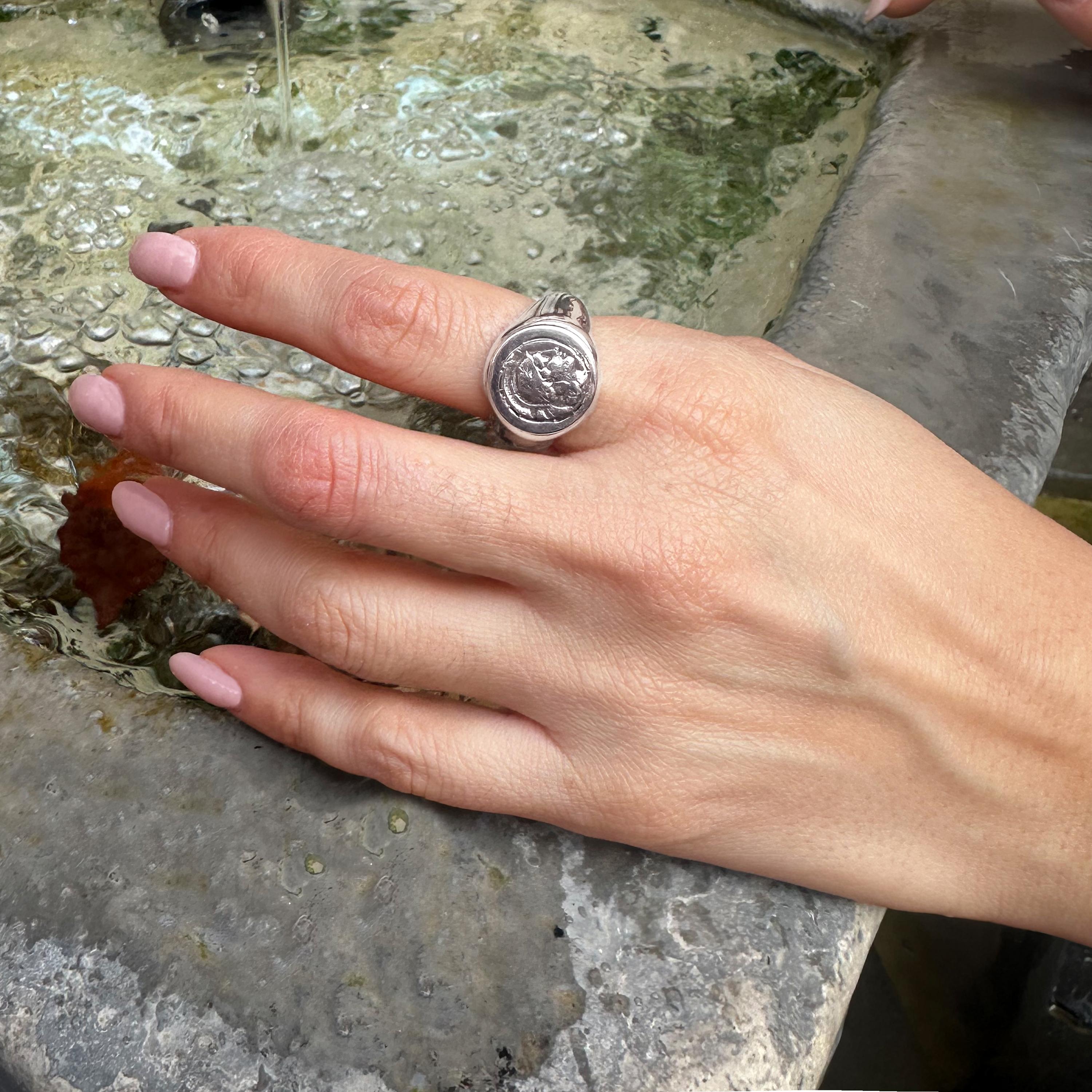 This sterling silver ring showcases an authentic Greek silver diobolus, sourced from an Athenian colony near Sybaris, founded in 443 BC. The coin's reverse side displays the image of a Bull.

Athena, one of the most renowned Greek Goddesses,