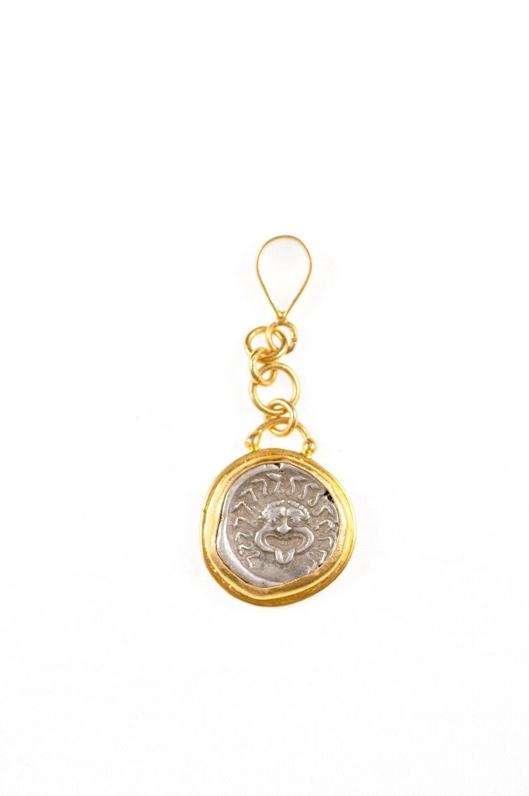 An authentic Greek Apollonia Pontika, AR Drachm Coin (Thrace, circa 450-400 BC), set in a rounded form 22k gold bezel with 22k gold drop linked chain and bail. The obverse, or front, side of this coin features the head of Gorgoneion with a