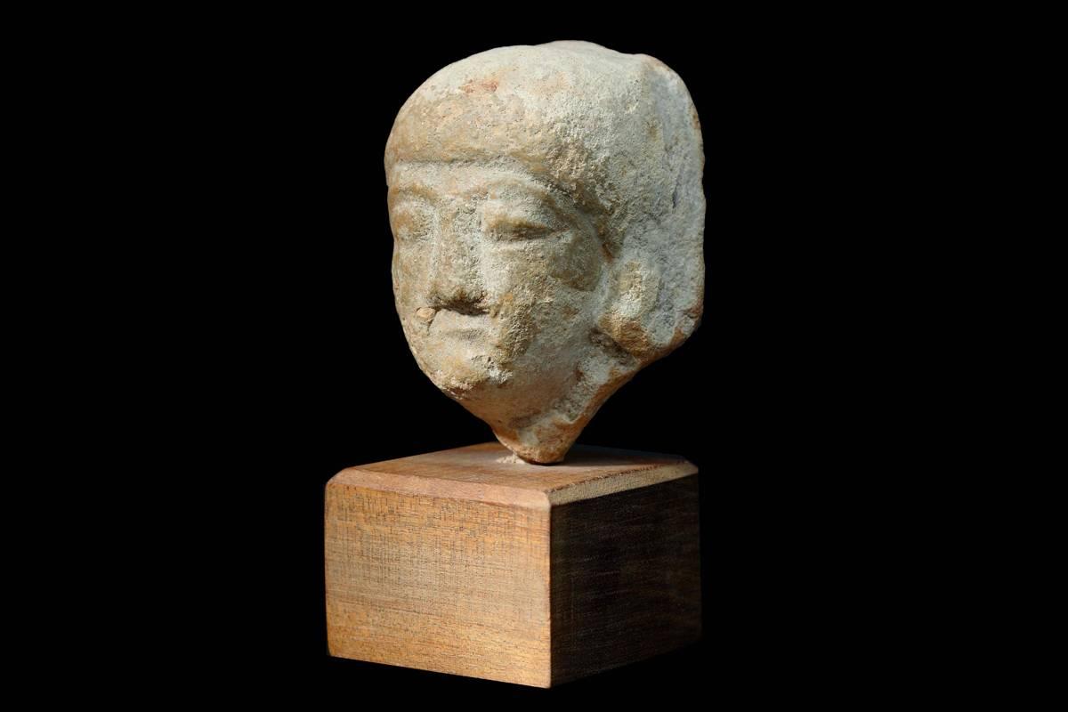 The head comes with an international Certificate of Authenticity.

The ancient Cypriot votary is wearing a tight cap covering his ears and hair, the profile shows a straight, triangle-shaped nose under arched eye brows and carved contours of