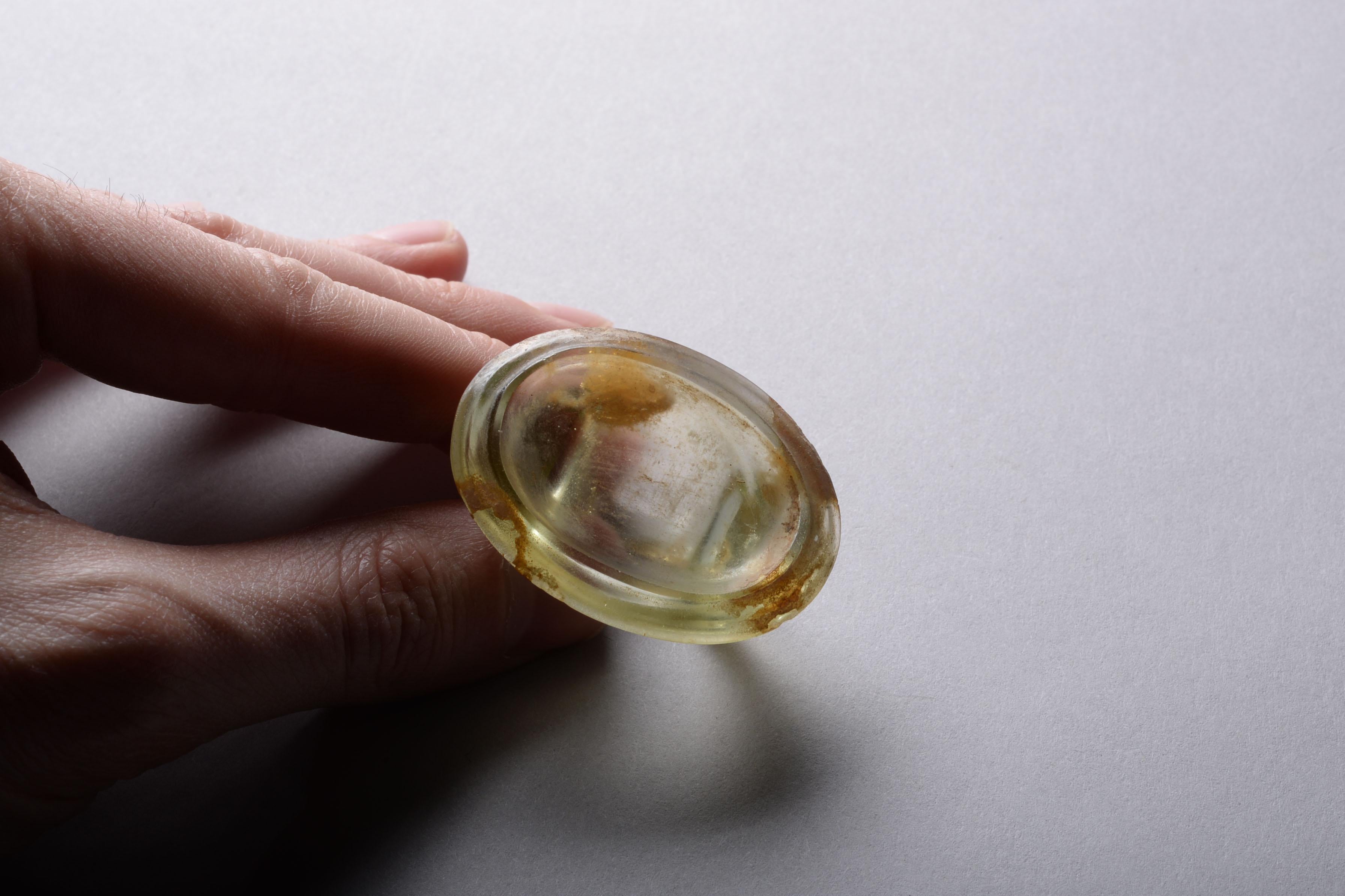 Dieser wunderschön erhaltene hellenistische Glasring ist ein zeitloses und beeindruckendes Stück antiken Schmucks. Das aus transparentem, hellgrünem Glas gegossene Schmuckstück mit seiner großen, ovalen Lünette, die ursprünglich verziert war, ist