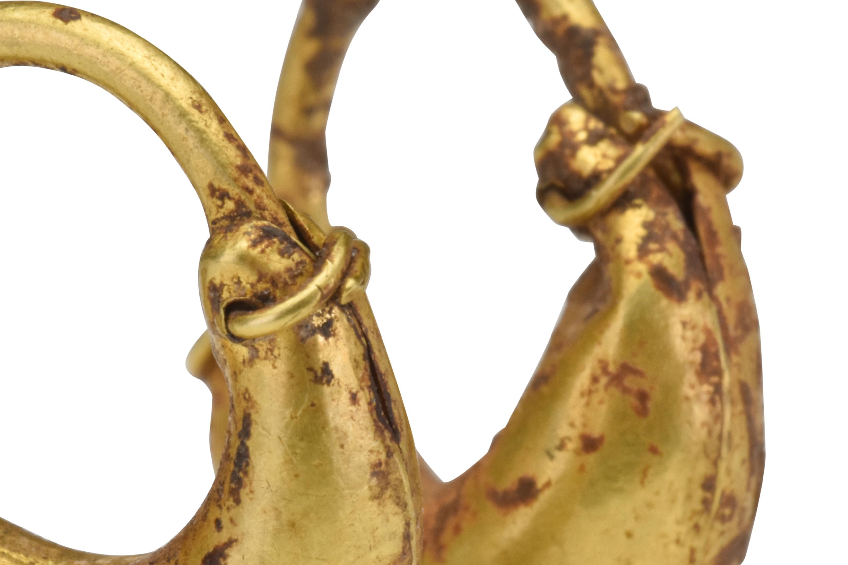 Antike griechisch-hellenistische Gold-Ohrringe in Bootsform 

Griechisch-hellenistisch, ca. 300-200 V. CHR

Ein wunderschönes Paar schiffsförmiger Hohlkörper-Ohrringe. Sie verjüngen sich jeweils zu einem dünnen glatten Draht mit einem