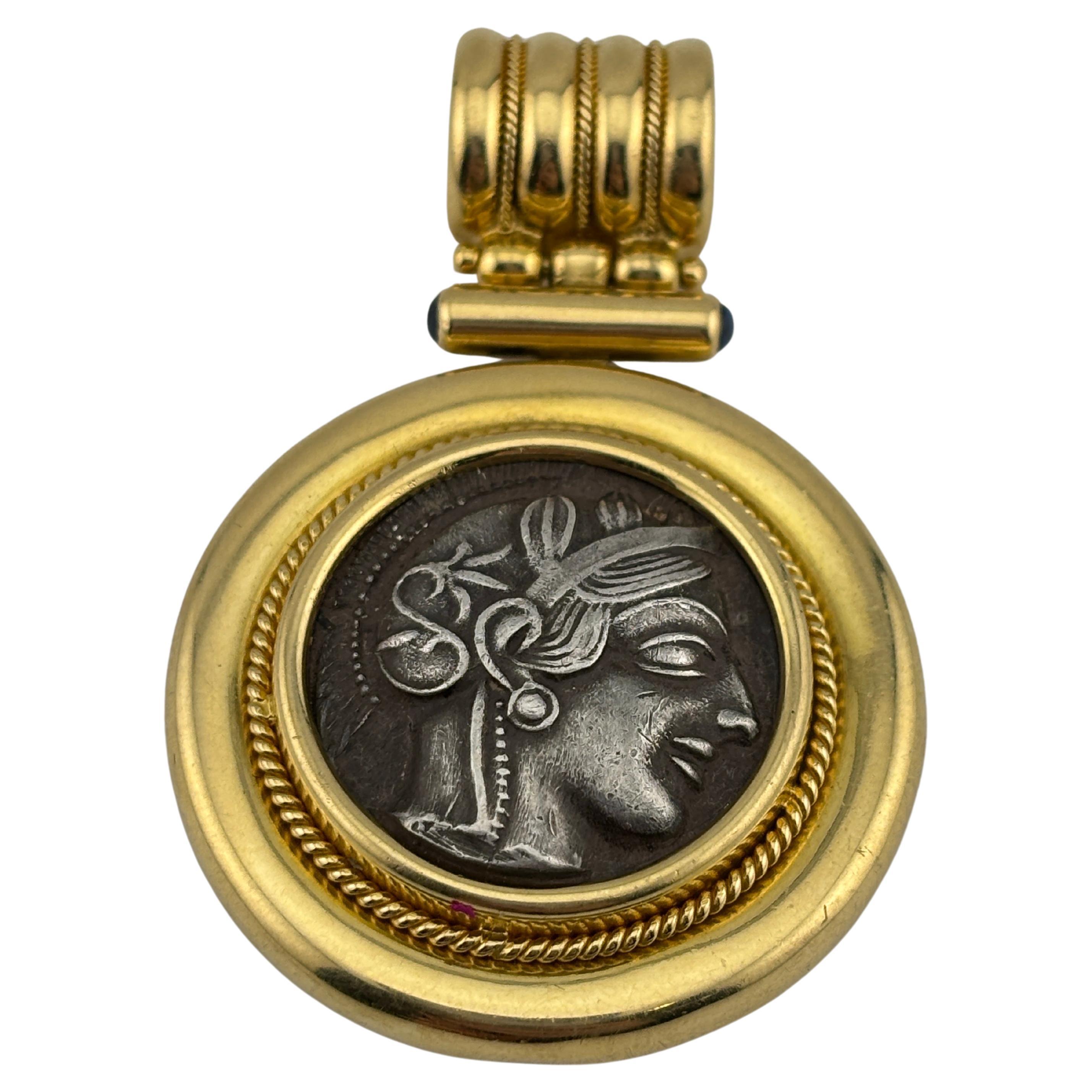 Questa moneta in argento sterling è ispirata a un antico tetradramma greco e illustra Atena e la saggia civetta. La moneta è incastonata in oro giallo 18 carati. Si tratta di un gioiello sorprendente e ricco di storia, che unisce l'arte antica al