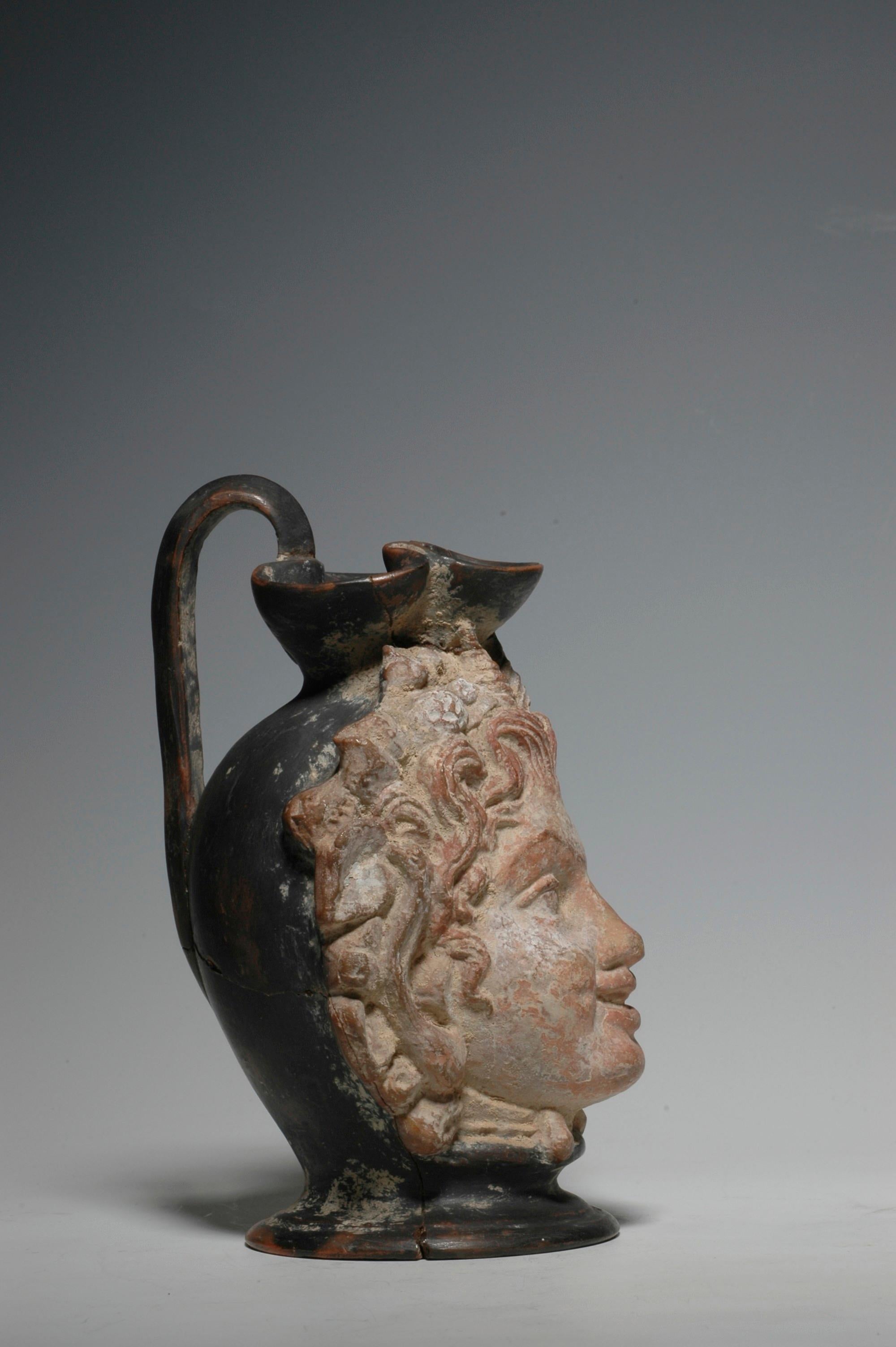 Western Greek trefoil head vase with a very lively face of a faun and well preserved polychrome, circa 4th century BC.
The vase is actually a trefoil oinochoe with a handle at the back of the head. A very unusual and rare piece. Provenance: ex. the
