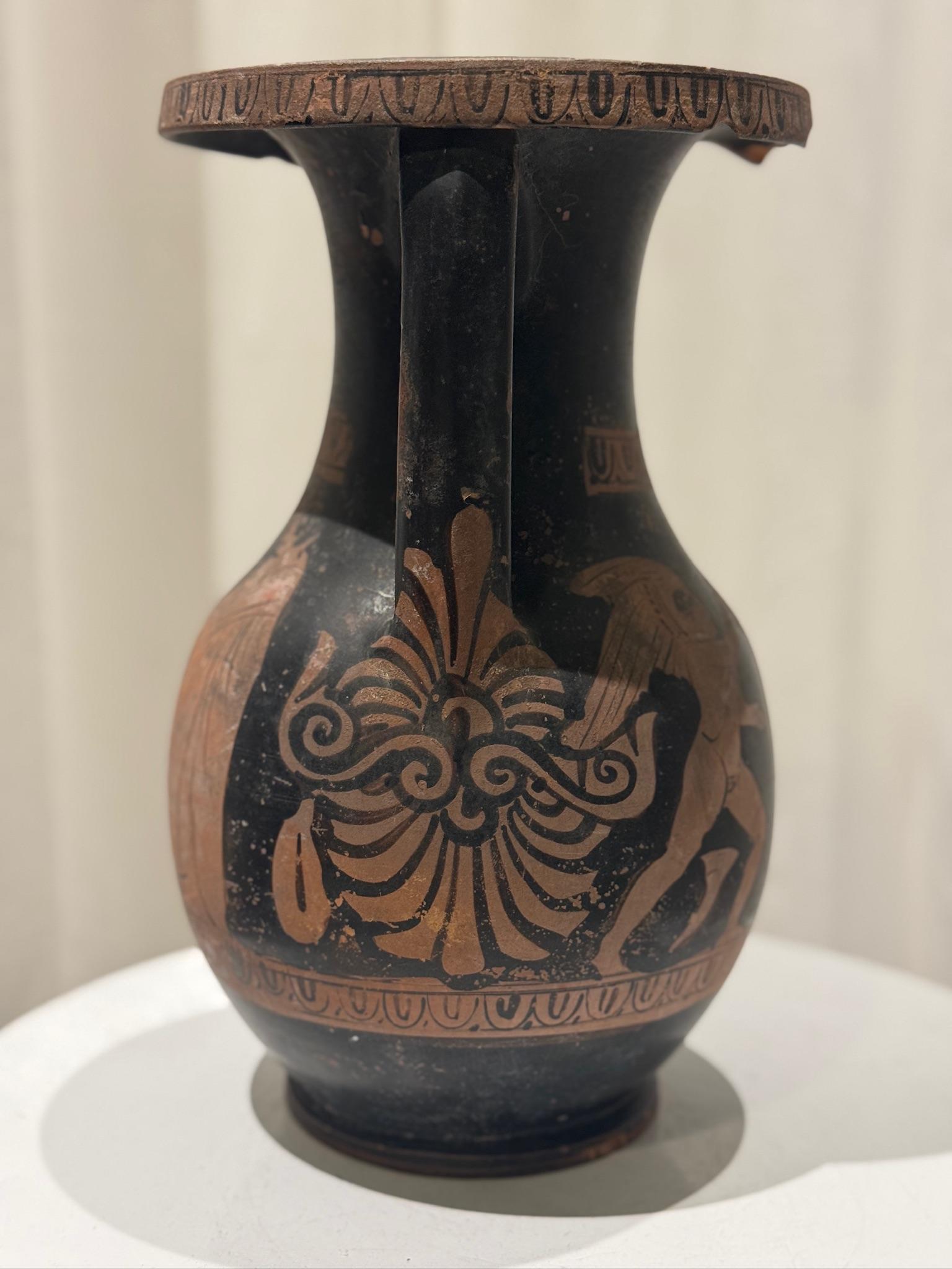 Presenting an exquisite ancient Greek red-figure terracotta pelike (storage jar) standing 10.5 inches tall. This piece embodies the timeless artistry of Classical Greece, featuring hand-painted figural motifs in the iconic red-figure style (red