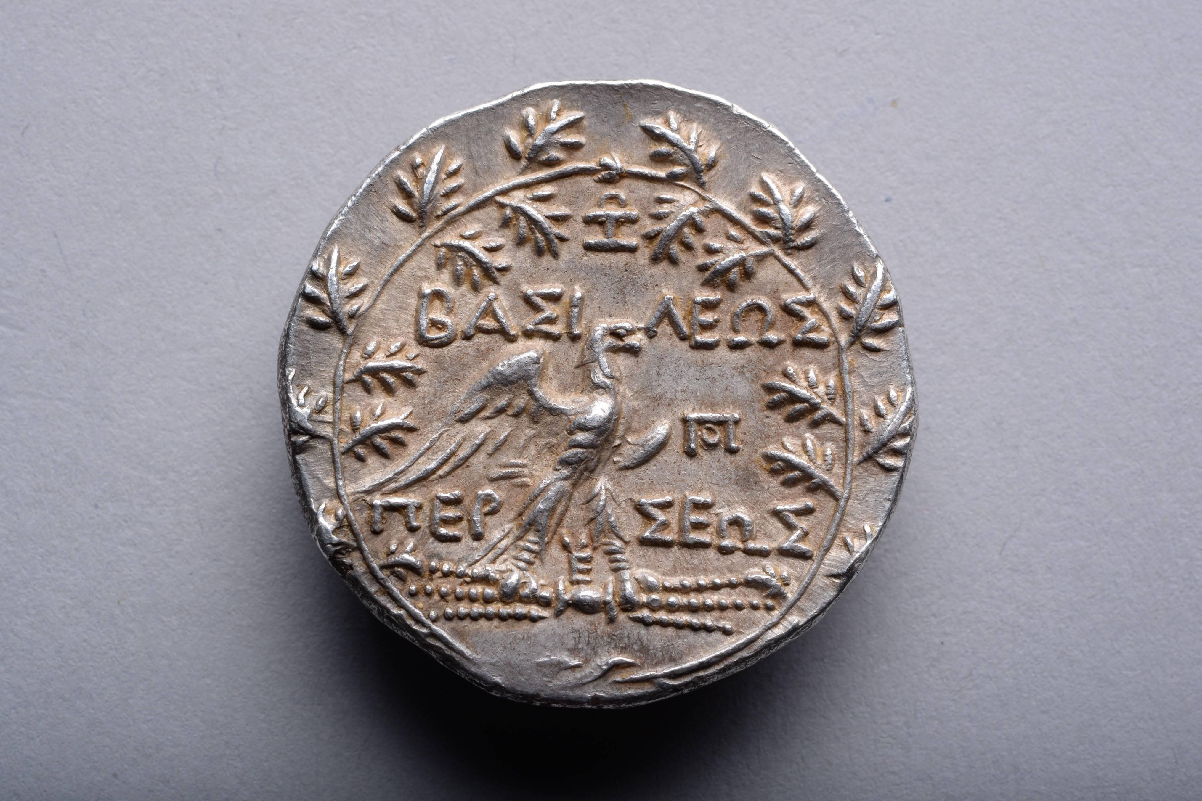 A silver tetradrachm minted under King Perseus of Macedon. Issued under magistrate Zoilos at the Pella or Amphipolis mint, circa 174 - 173 BC.

The obverse with the head of Perseus, a diadem cutting through the rough curls of his hair.

The reverse