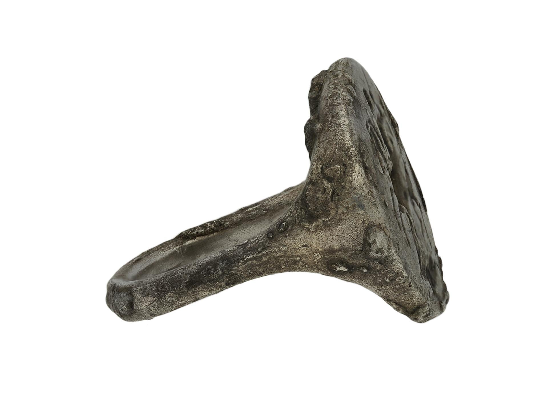 Ancient Greek silver ring with hunting scene. A substantial silver ring with a central oval shaped plaque finely engraved with a horse ridden by a hunter holding a spear, with a boar at their feet, flanked by smoothly conforming shoulders flowing