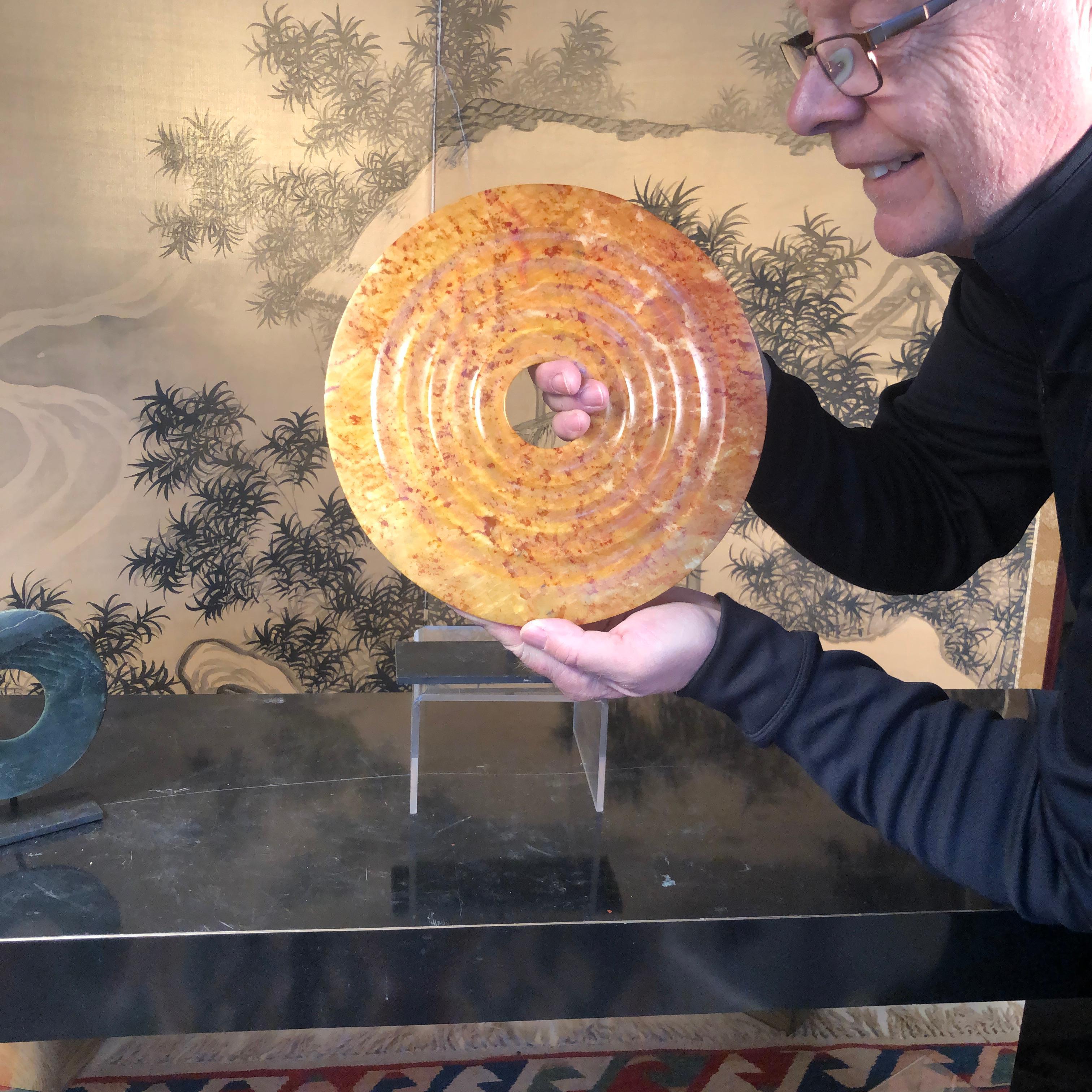 A Chinese jade bi disc of orange hue from the Qi Jia culture, Northwestern China, 3,000-2,000 BCE and coming from our private collection. 

Dimensions with stand: tallest 11.5