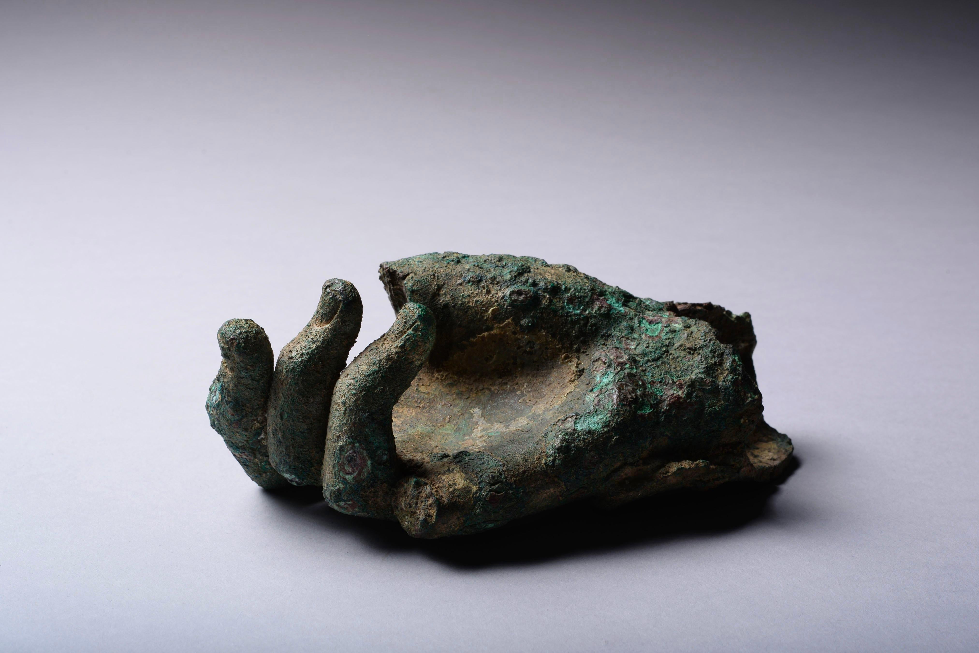 A fragment from a bronze statue, Hellenistic to early Roman 1st BC-1st century AD.

Preserving the right hand and wrist, the thumb and small finger lost, the remaining fingers finely modelled and curled towards the palm, presumably once grasping a