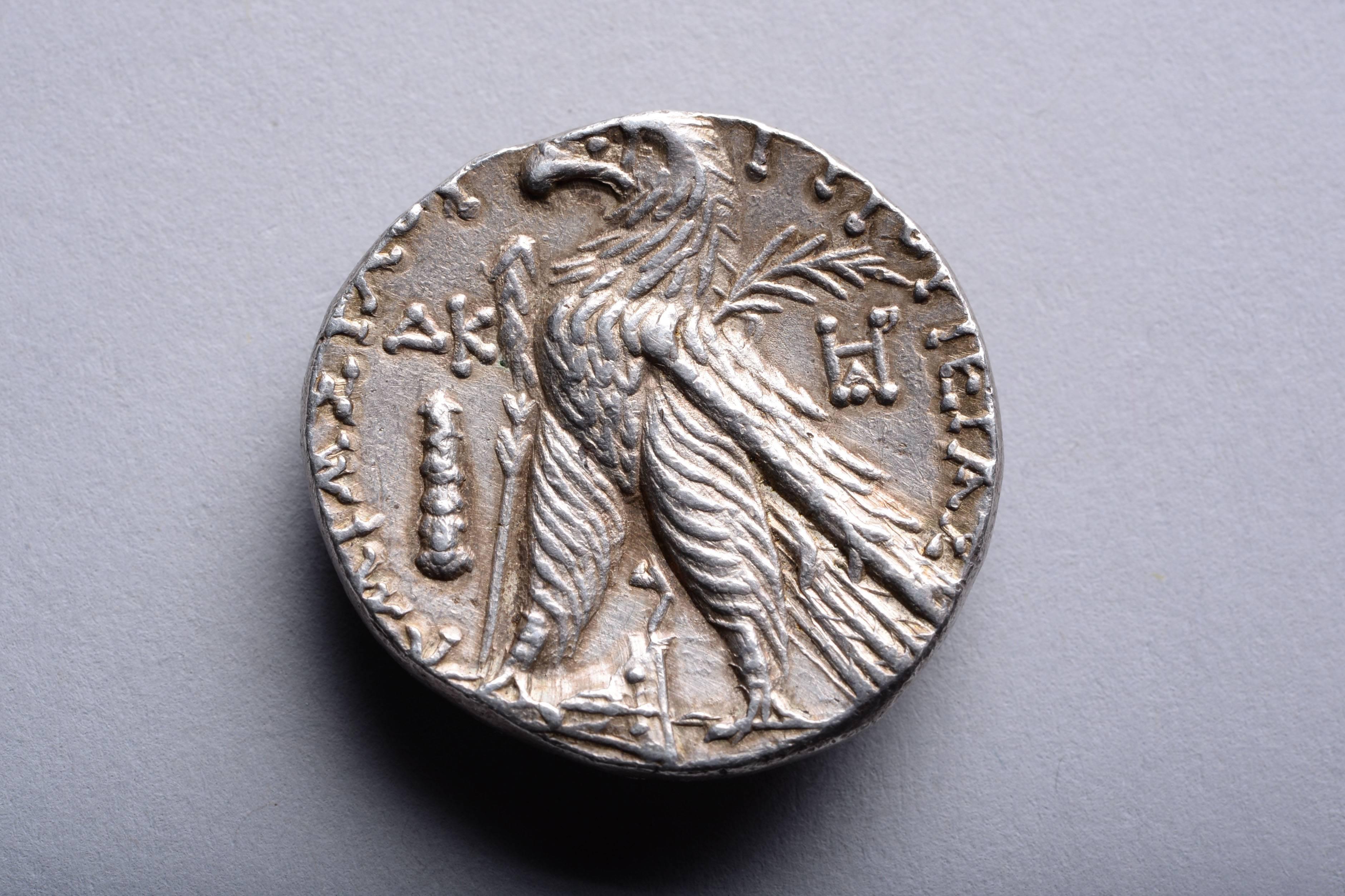 A silver shekel from the city of Tyre, minted in year 24 of the Tyrian calendar, 103 / 102 BC.

The obverse with the portrait of the god Melqart (chief deity of Tyre), wearing laurel wreath.

The reverse with eagle, standing on ship's prow, palm