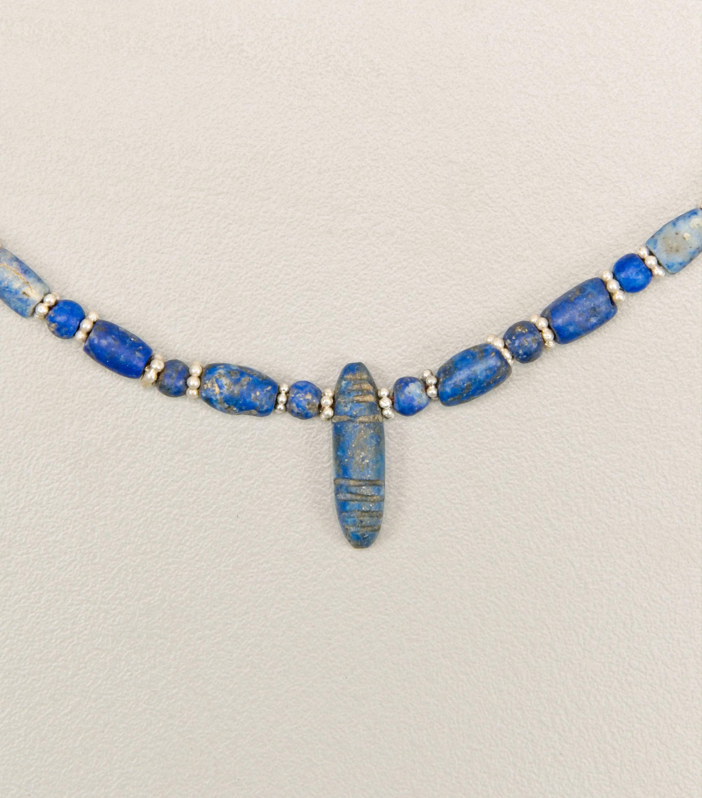 Seventy- five lapis lazuli beads with a center pendant bead. There are thirty-six barrel shaped beads and thirty-eight round beads each spaced by a silver ring bead. There are seventy-six of these silver beads which are composed of six grains that