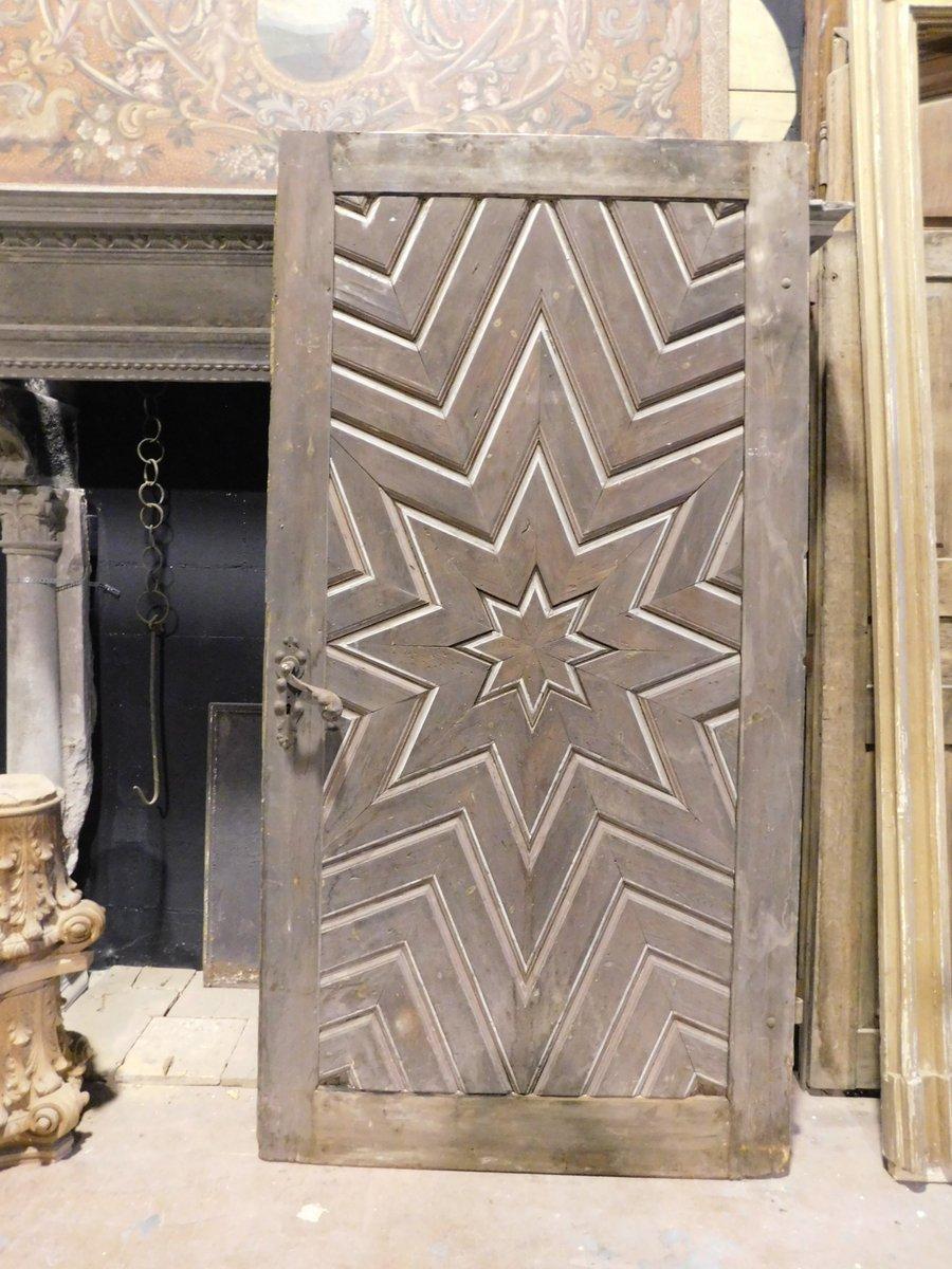 Ancienne porte intérieure en beau bois de mélèze, très sculptée avec une forme d'étoile composée de plusieurs pièces entrecroisées, construite au 19ème siècle en Italie pour une maison de montagne.
De belle patine et de belle facture, très
