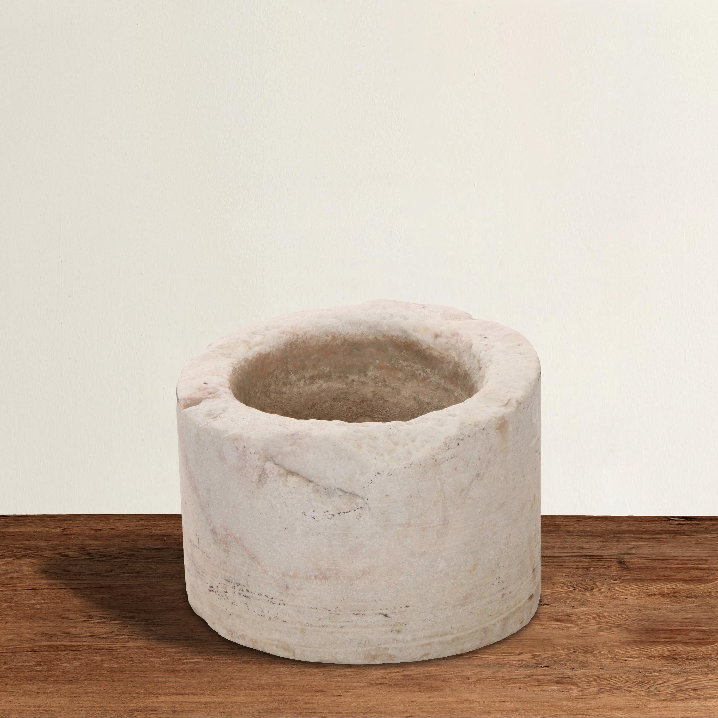 A gorgeous ancient vessel carved from one piece of marble with subtle pink veins running throughout. Perfect for use as a vessel sink in a powder room, filled with fruits and vegetables on your kitchen island, or planted with flowers on your patio.