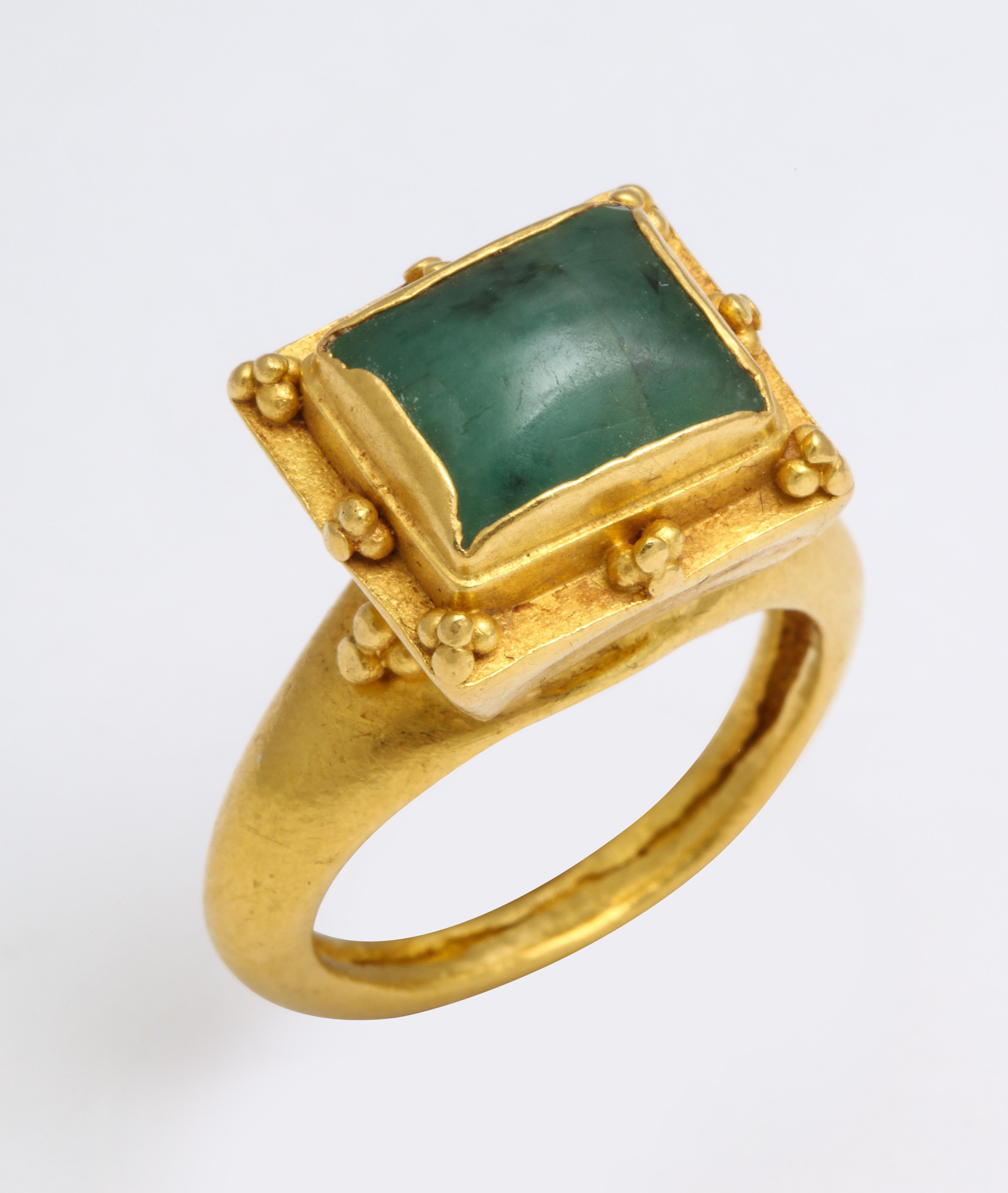 A rare 22 Kt. gold British ring with a circular shank is the stage for a trumpet bezel and square emerald stone. The setting is surrounded with elegant granulated decoration. The ring is gorgeous and likely belonged to a Medieval noblelady from the