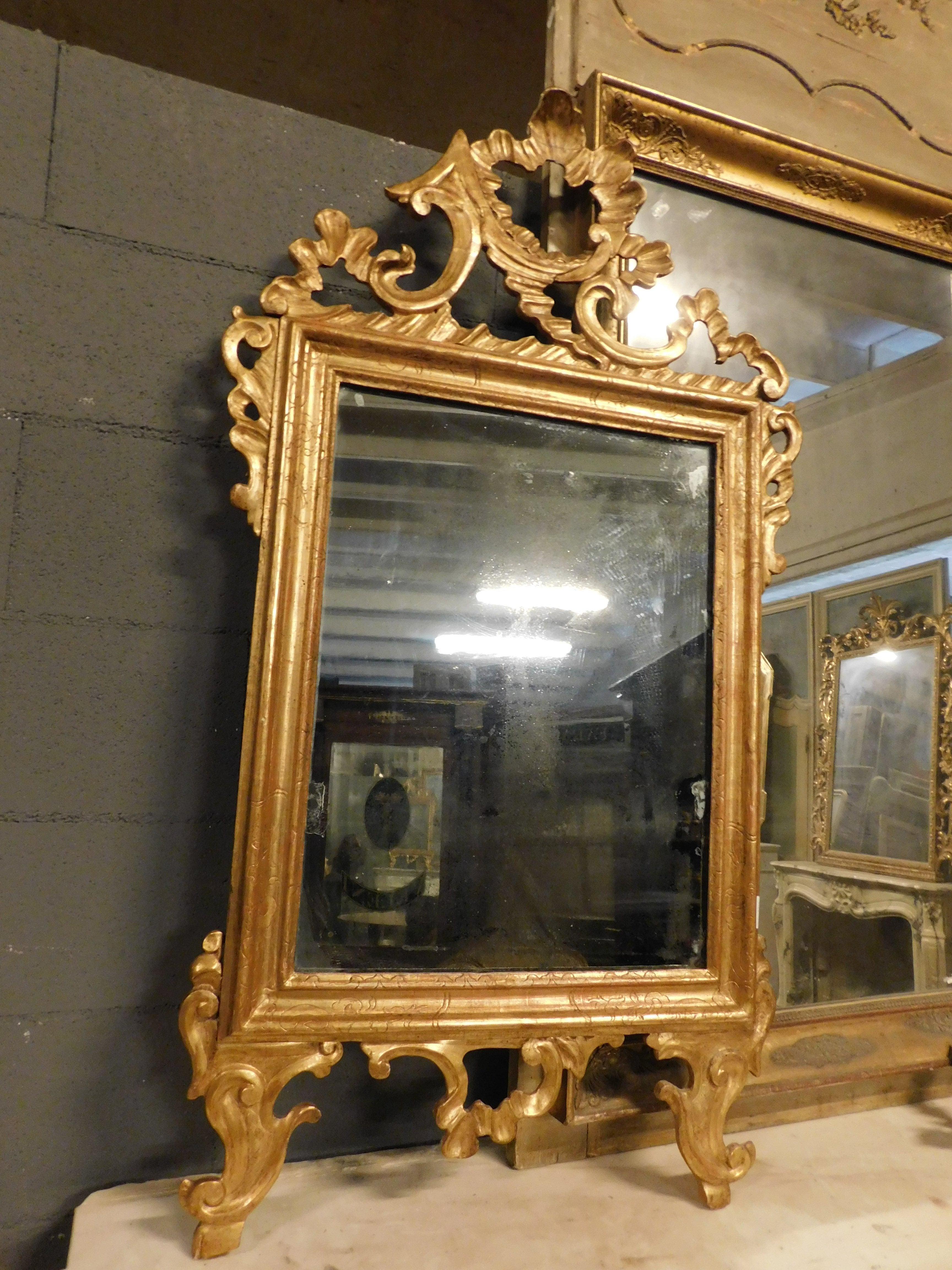 Ancient fireplace mirror, in gilded and carved wood with cymatium, from France from the late 19th century, it was placed above an antique chest of drawers but can also be placed above a fireplace, in a boiserie or in a modern bathroom, maximum size