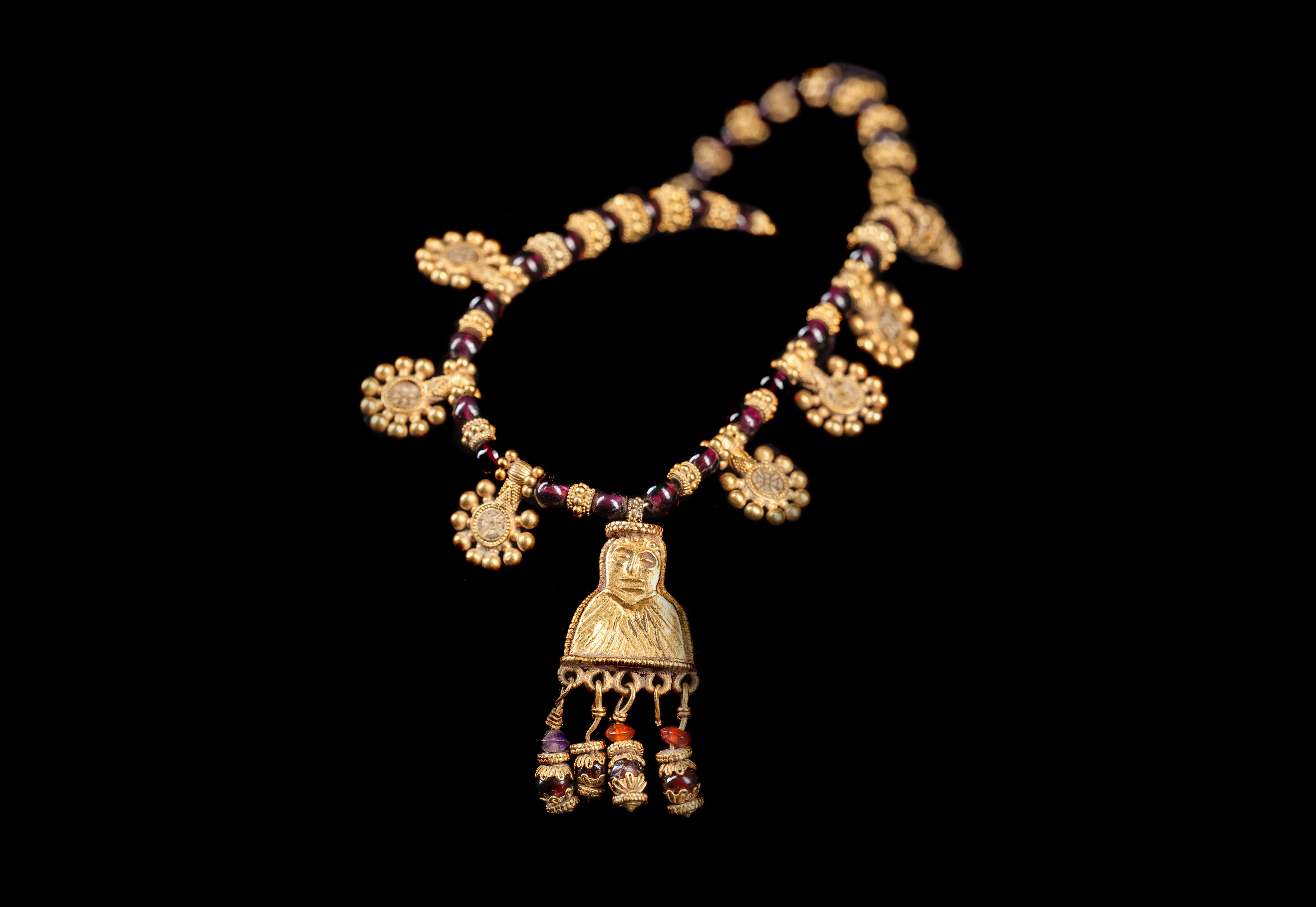 An ancient Hellenistic period necklace from, 3rd-1st Century B.C., South Arabia, possinly Yemen. This remarkable necklace is composed of spherical garnet beads, interspersed alternately with gold, granulated spacer beads. At the centre hangs a