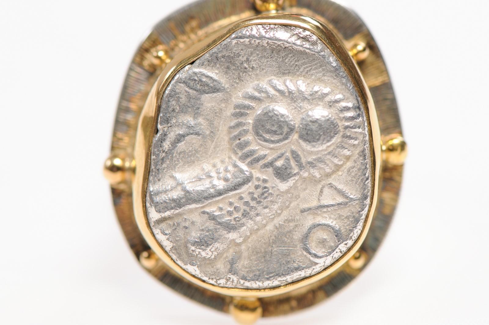 An authentic Attica, Athens, Silver Tetradrachm Coin (circa 350-300 BC) ring. This Greek coin with Owl featured prominently has been set in a custom custom ring with a 22k gold and sterling silver bezel (with balled accents) and a sterling silver