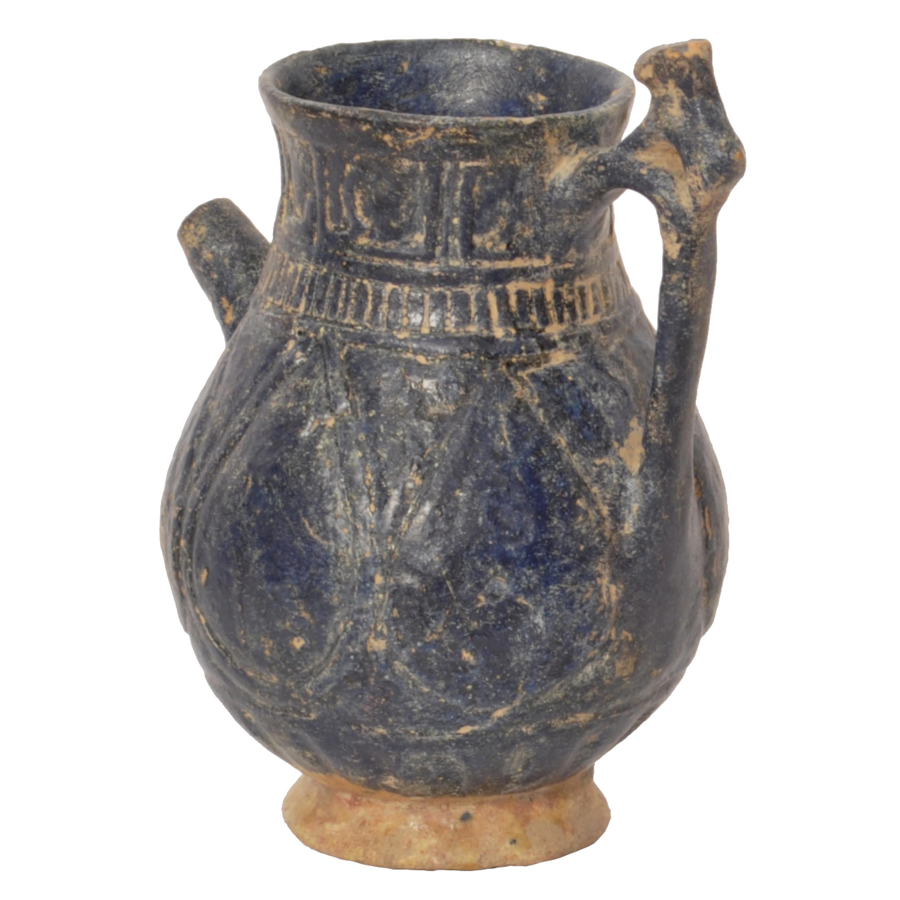 A rare ancient Persian totally intact 12th/13th Century Islamic vessel/jug, from Khorasan.
The vessel with a deep blue glaze and having a band of incised Islamic caligraphy to the top, the baluster shaped body decorated with incised 'teardrop'