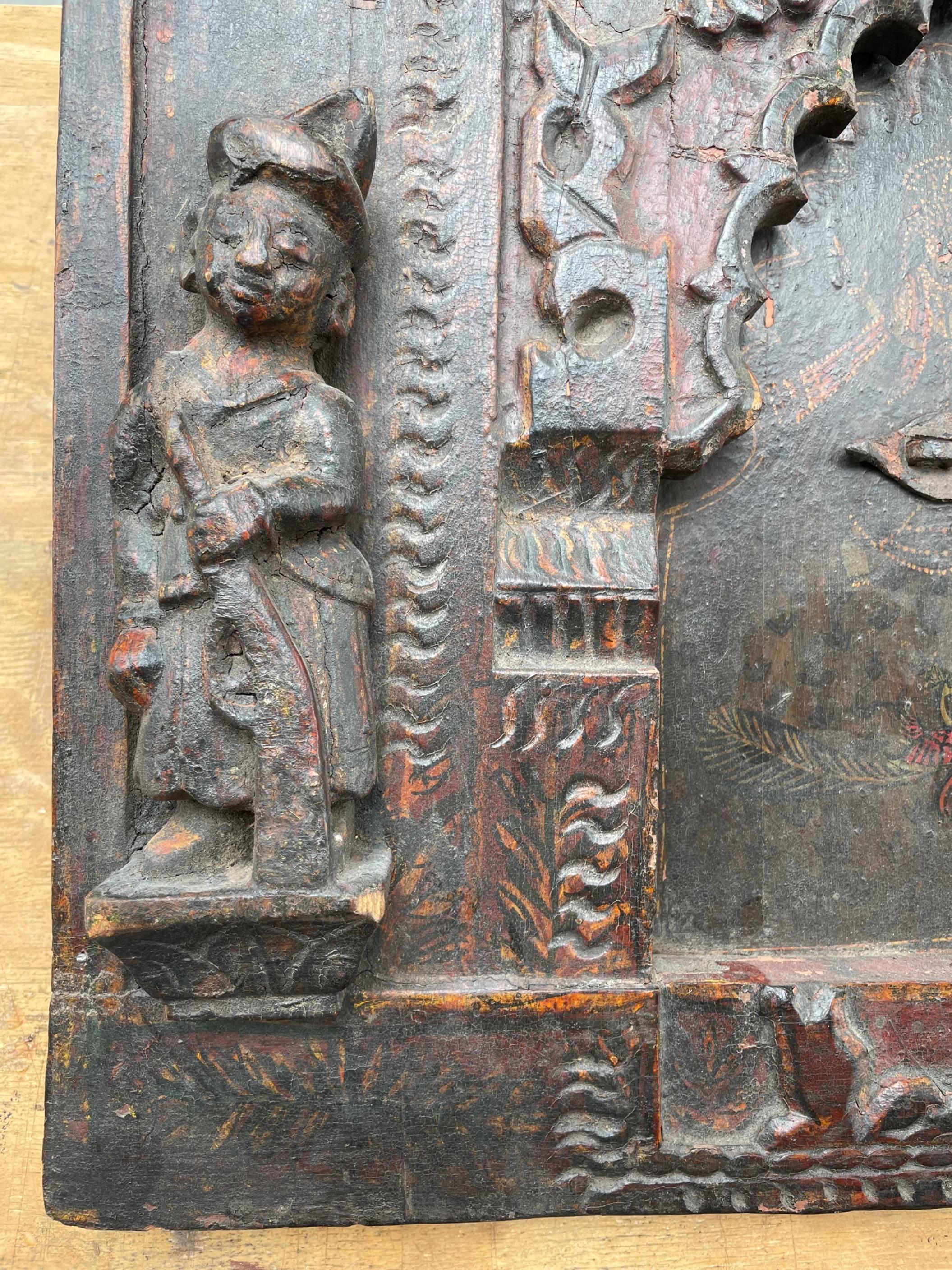 Ancient rare India wood hand carved polychrome wall panel with iron lock.

Exciting and dramatic wood carving of a wall panel from India. It is probably from the 17th-18th century. Very heavy exotic wood is used to hand carve the frame with the