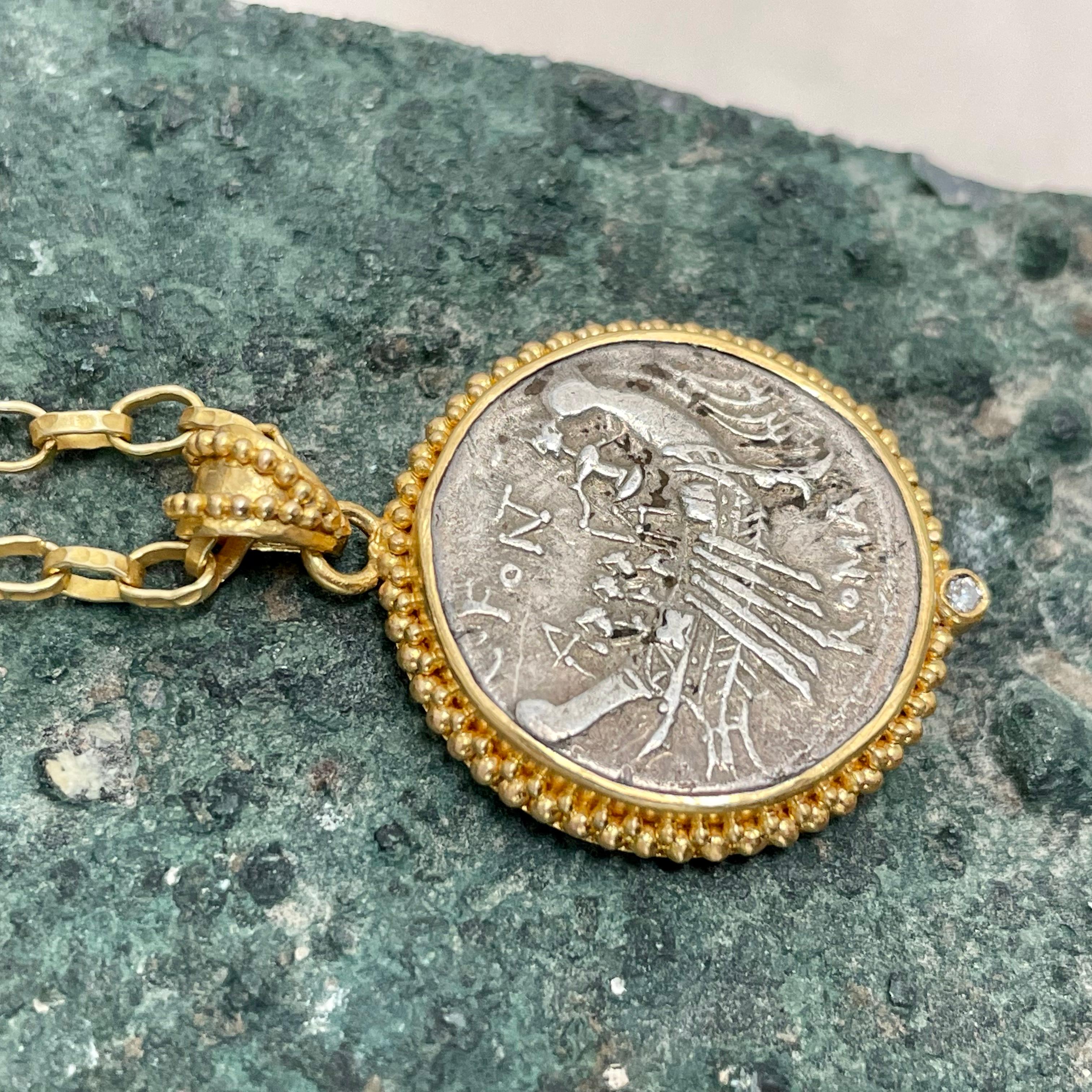 Une intéressante et authentique pièce de monnaie romaine républicaine en argent de 114 av. J.-C., représentant une galère romaine avec des rameurs et un pilote, est sertie dans une monture à lunette granulée 