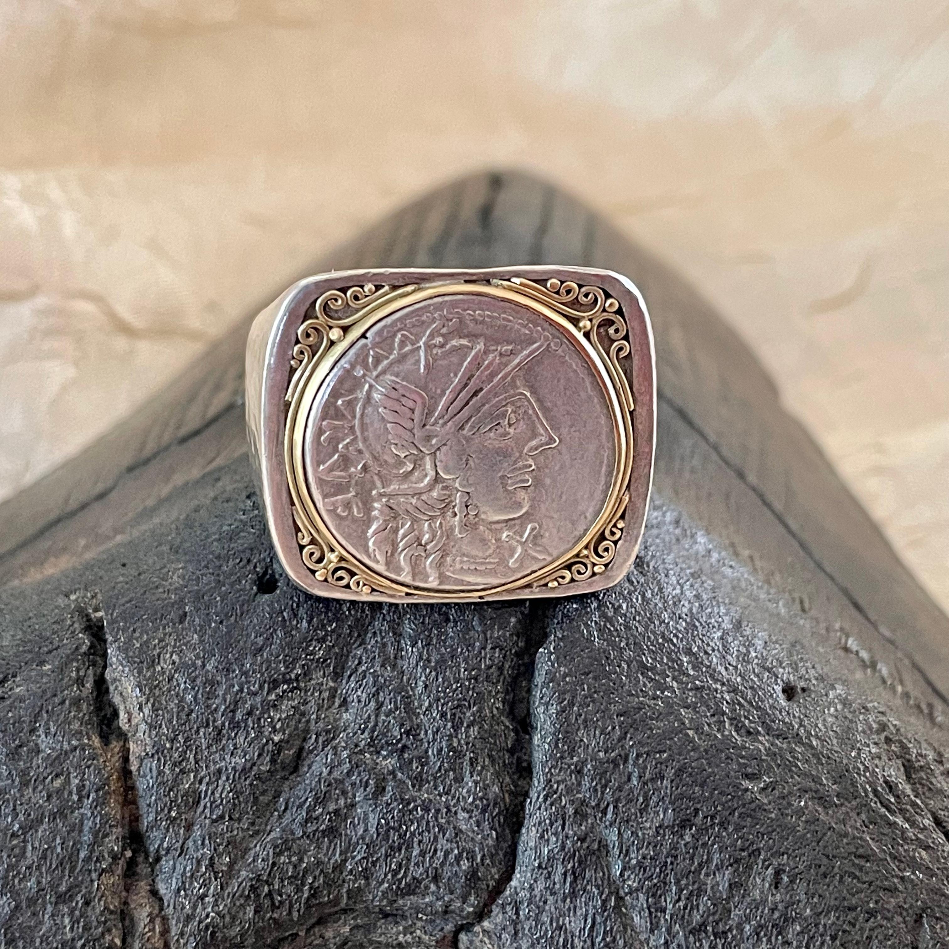An authentic denarius coin from the Roman Republic of 122 BC is set in signature 18K bezel surrounded by hand applied fine wire work in a wide rectangular mount atop a wide hammered matte-finish sterling silver shank in this Steven Battelle classic