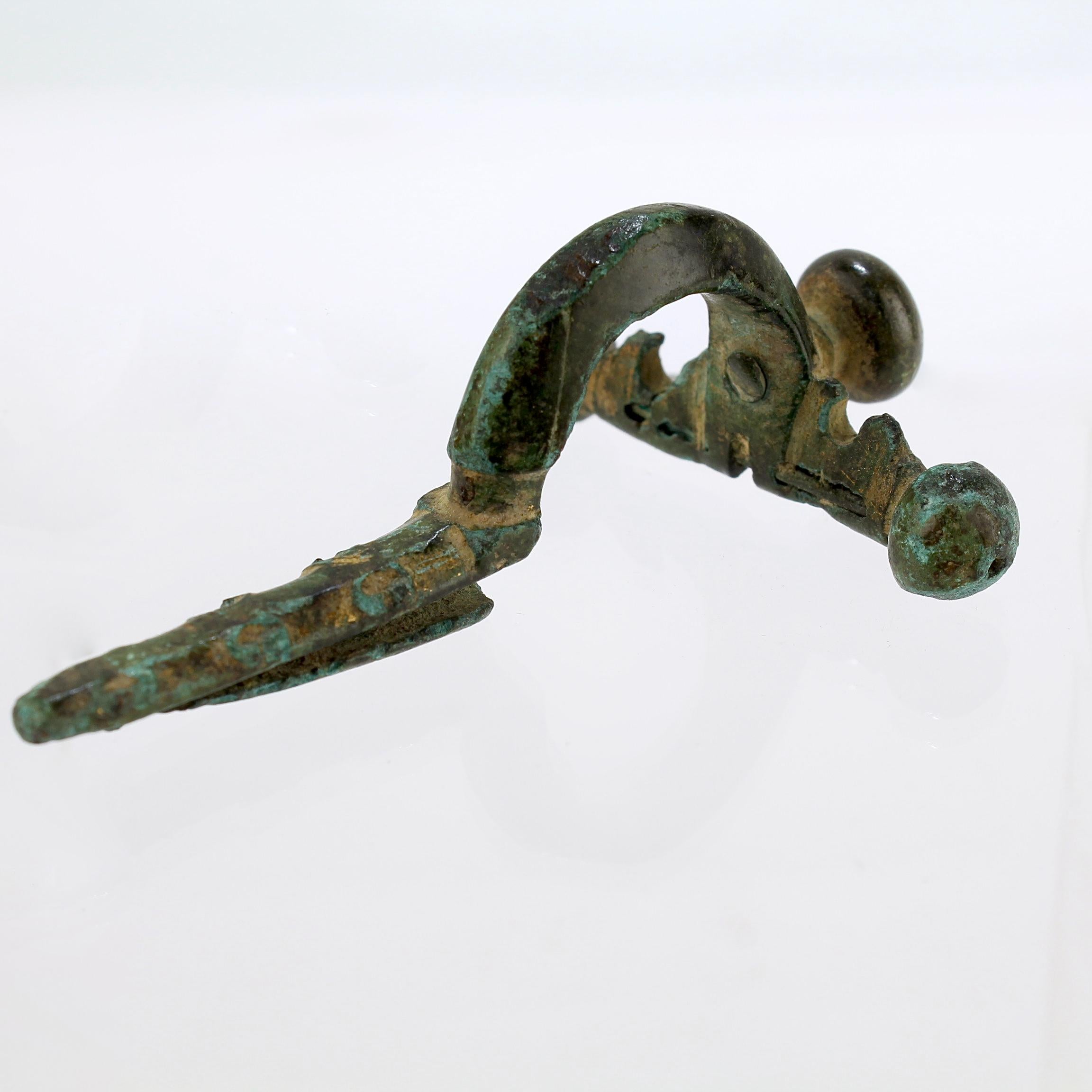 A fine ancient Roman bronze fibula.

A so-called crossbow fibula.

From the private collection of Lawrence Majewski, who was a former conservator at the Metropolitan Museum of Art. 

Simply a wonderful piece for the wunderkammer or curio