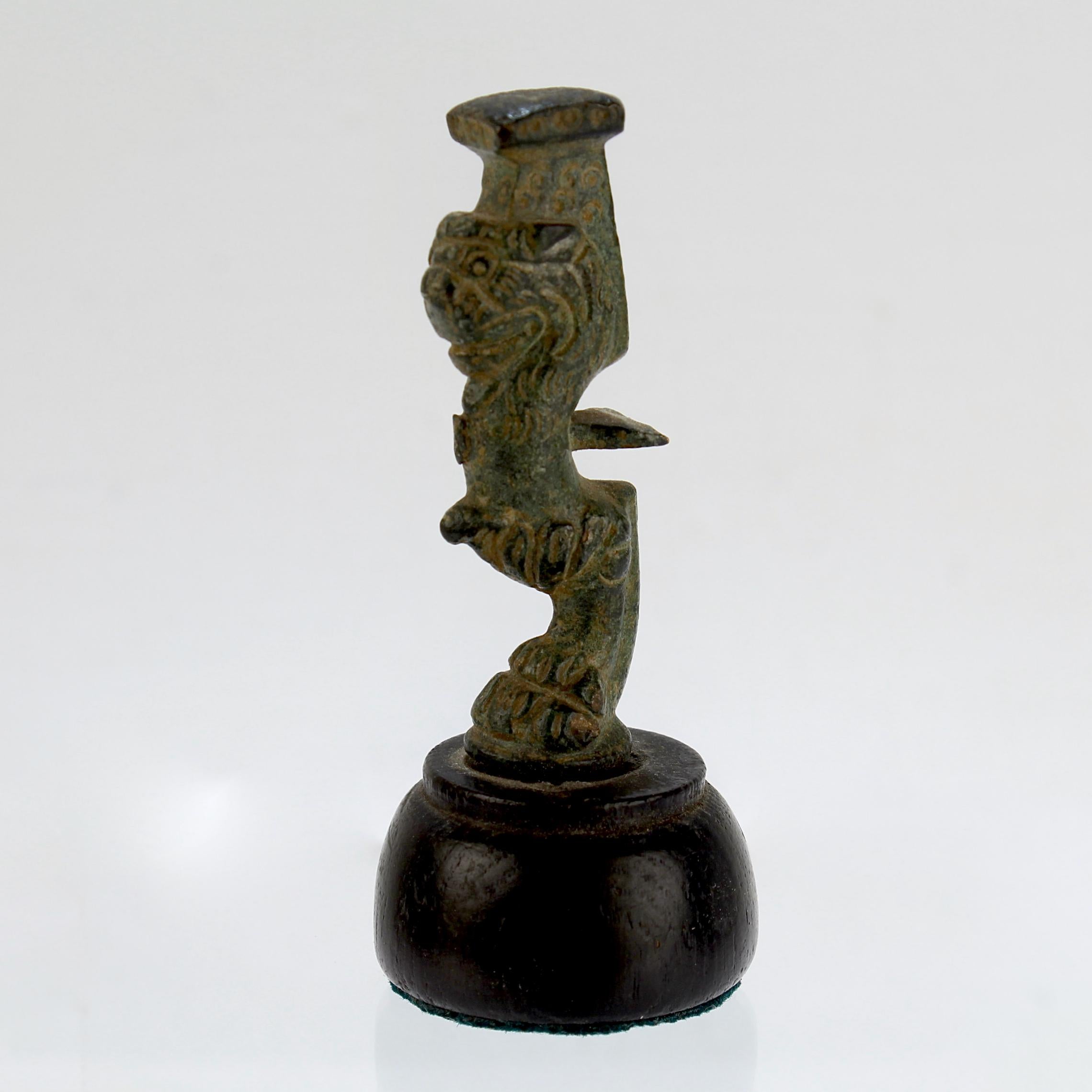Un bel élément en bronze de l'Antiquité romaine. 

Il semble s'agir d'un pied ou d'un support pour une structure plus grande.

La jambe a un pied en forme de sabot qui supporte une tête de lion et une plate-forme carrée au-dessus. Le pied